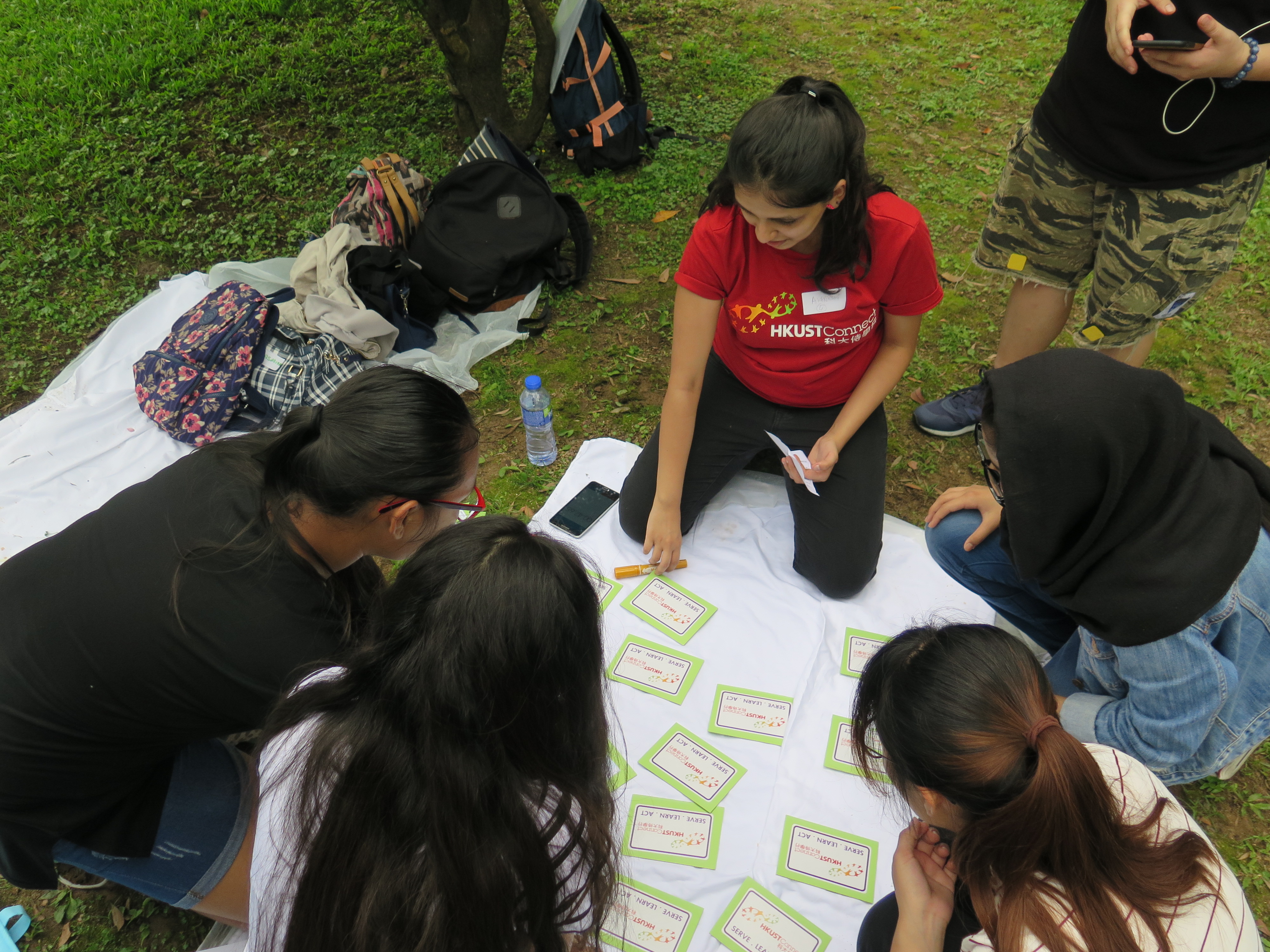 Volunteers playing a card game with the service recipients in the outing location
