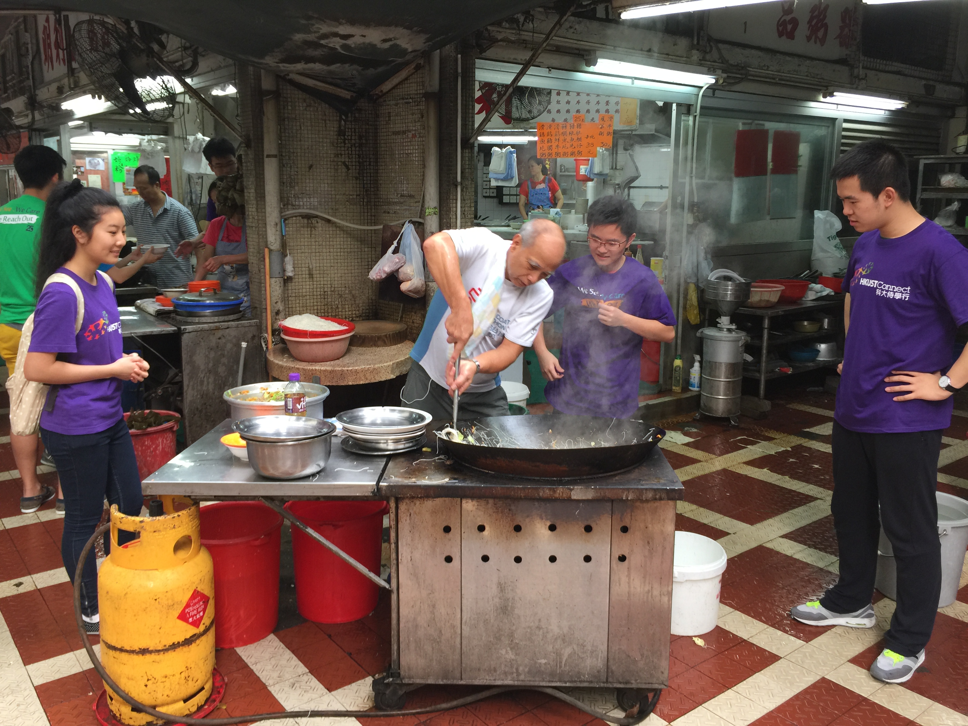 Mr. Li teaching volunteers the right way to stir-fry vermicelli