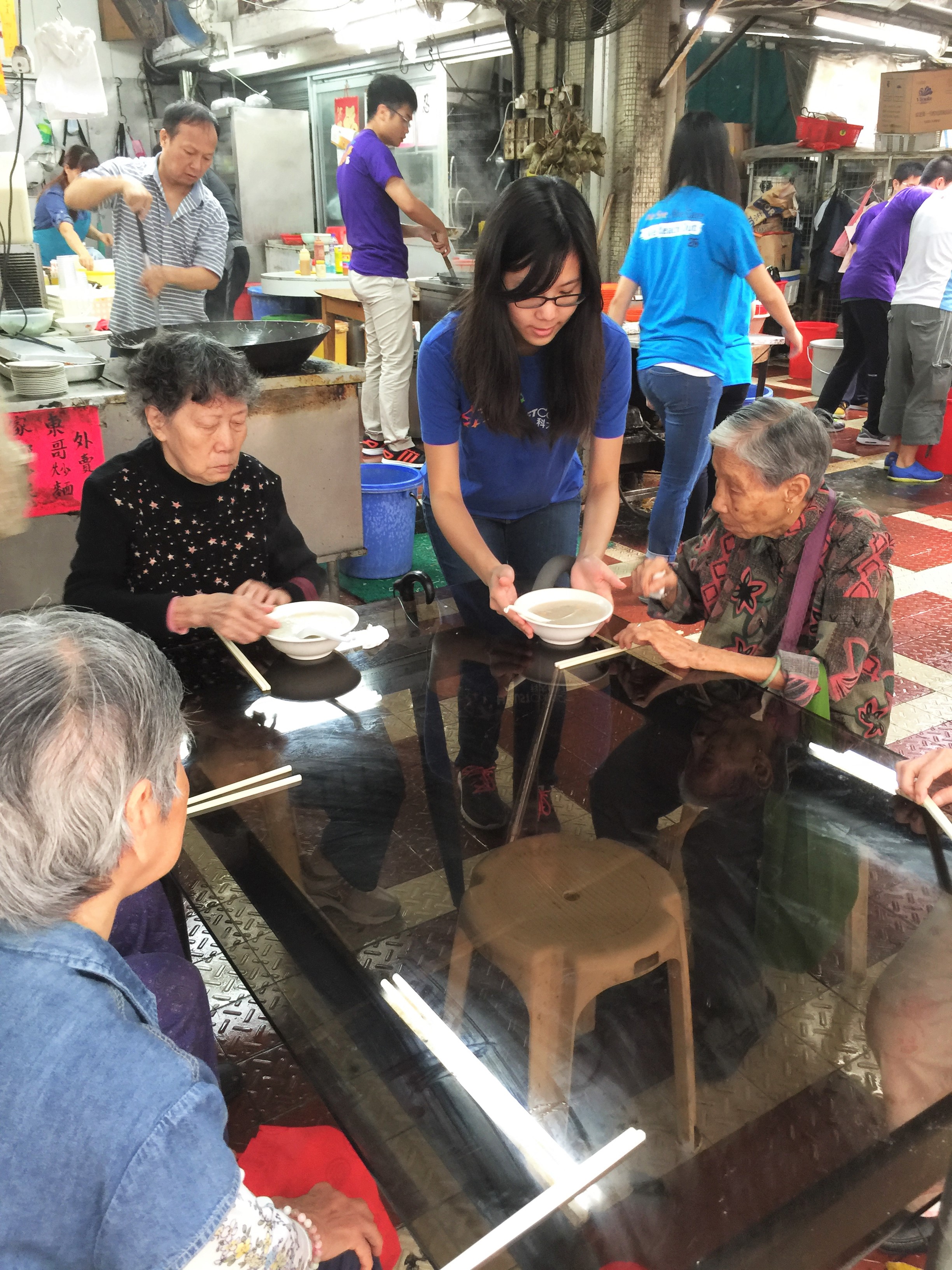 Volunteer helping in distribution of congee to the elders