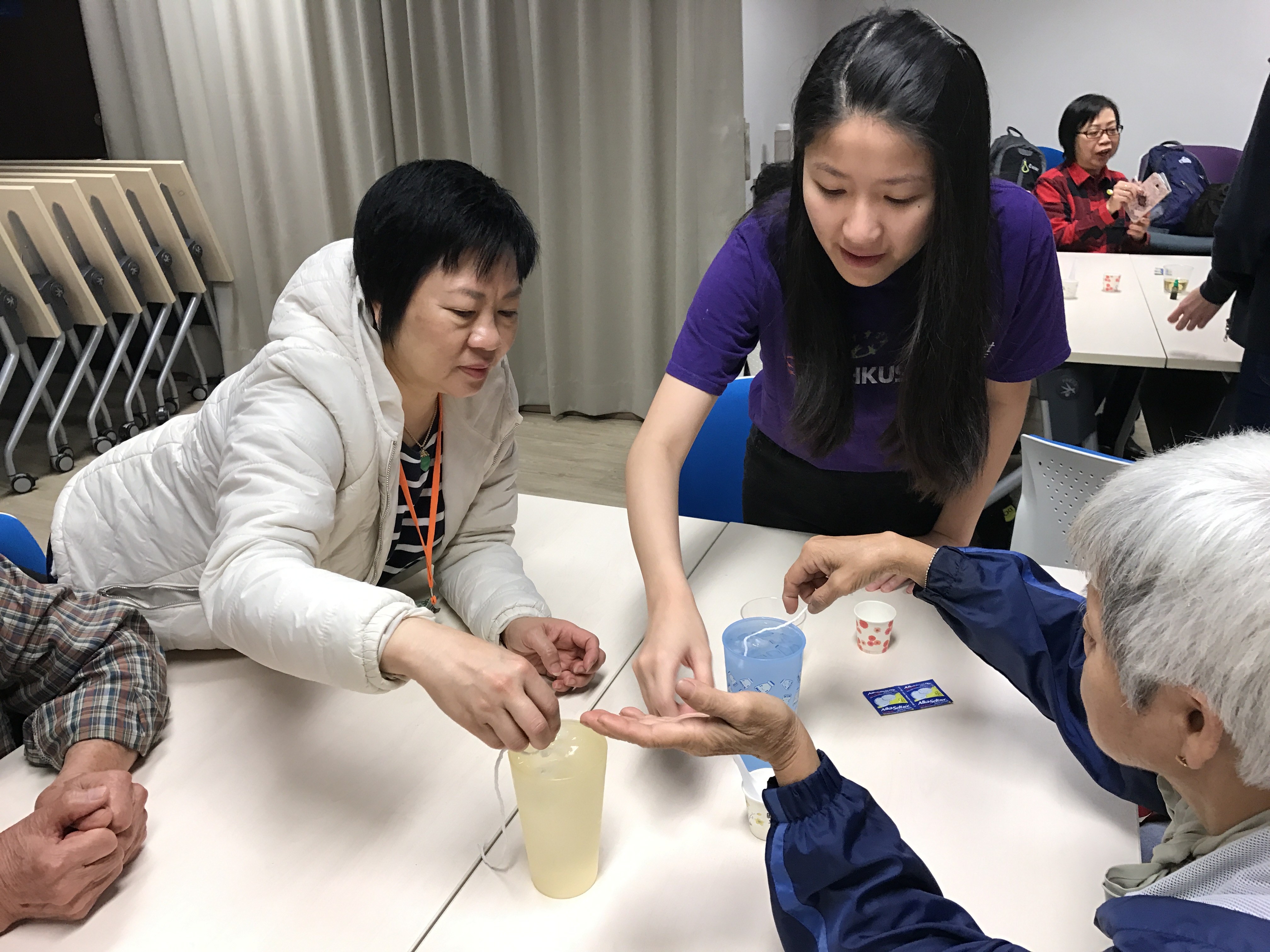 Volunteer guiding the elderly to do an interesting experiment