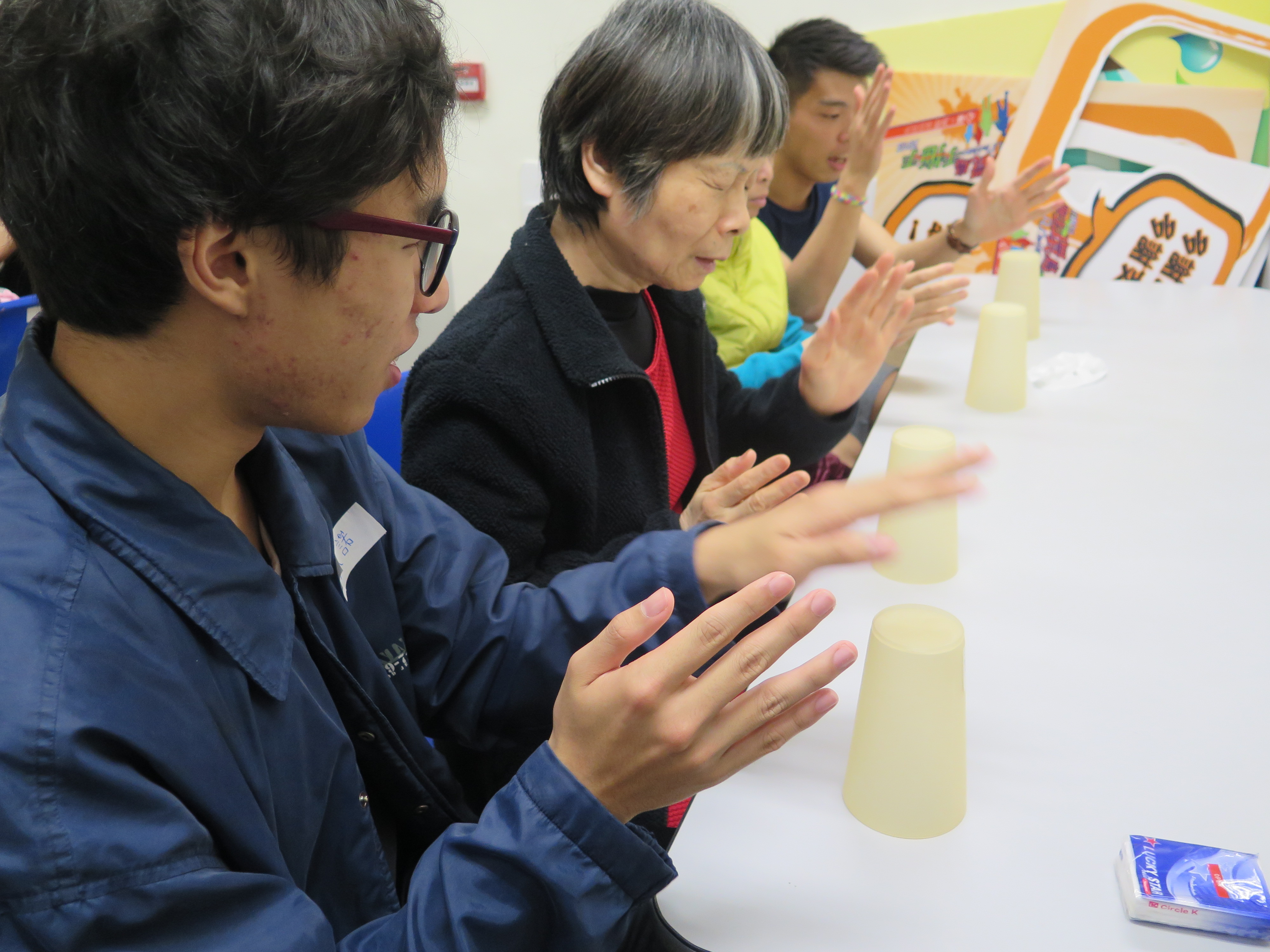 Volunteers teaching the visually impaired people to play the Cup song