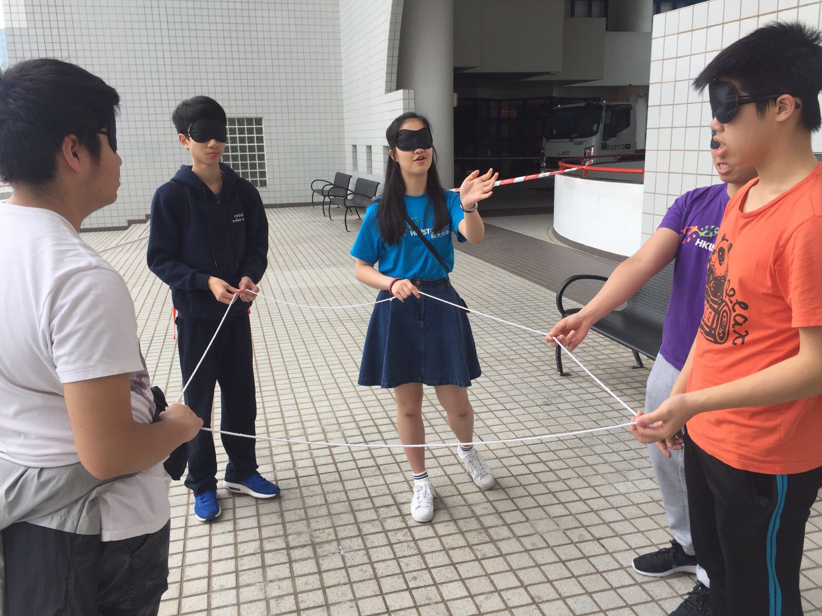 Students playing a team building game with a rope 