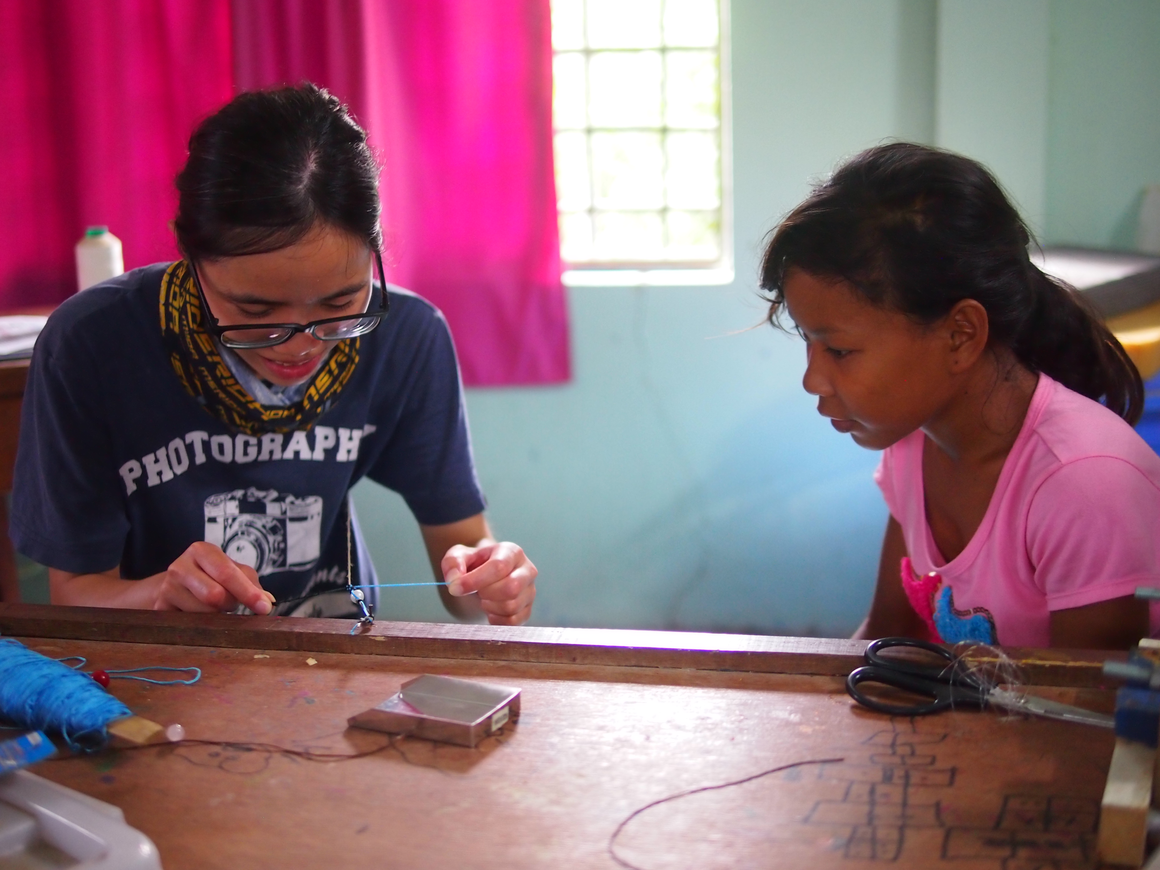 Children teaching our volunteers how to make a jewelry
