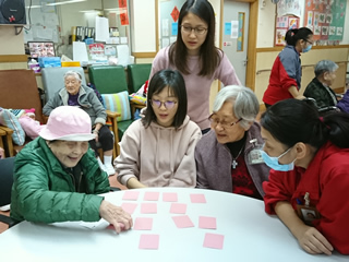 Volunteers playing card games with the elderly