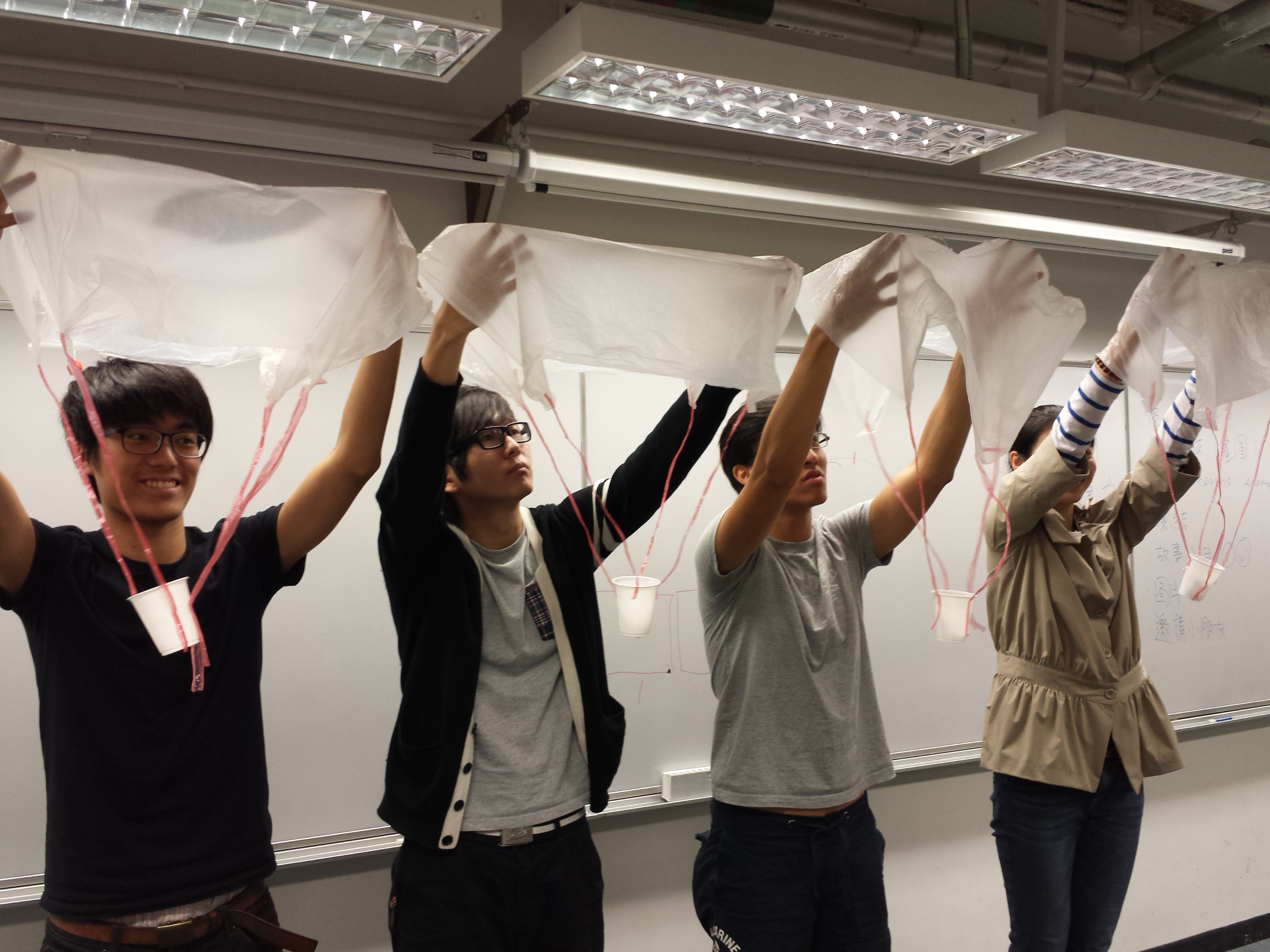 Volunteers demonstrating how to make parachutes during the workshop