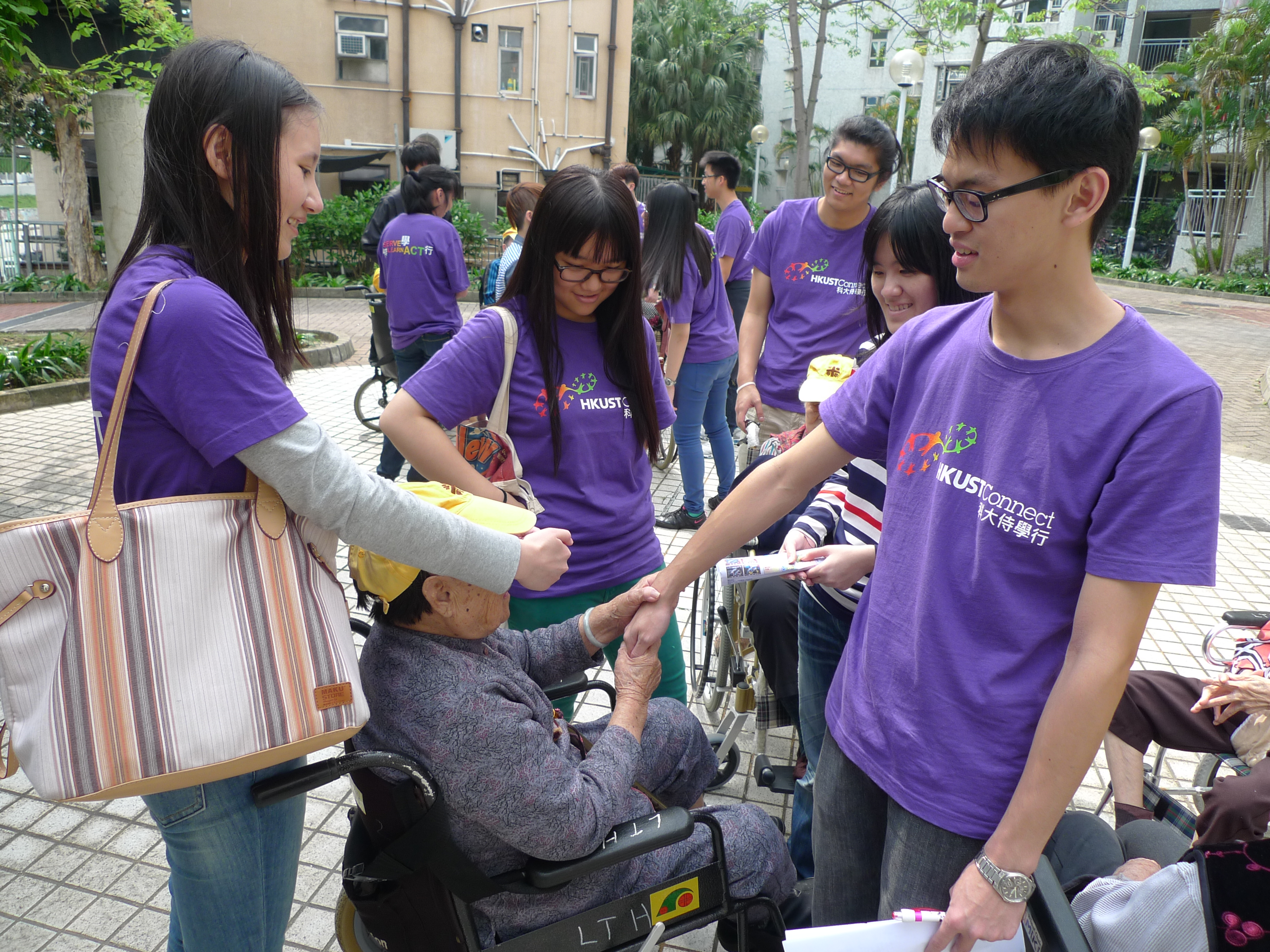 An elder guessing who the volunteers are by touching their hands