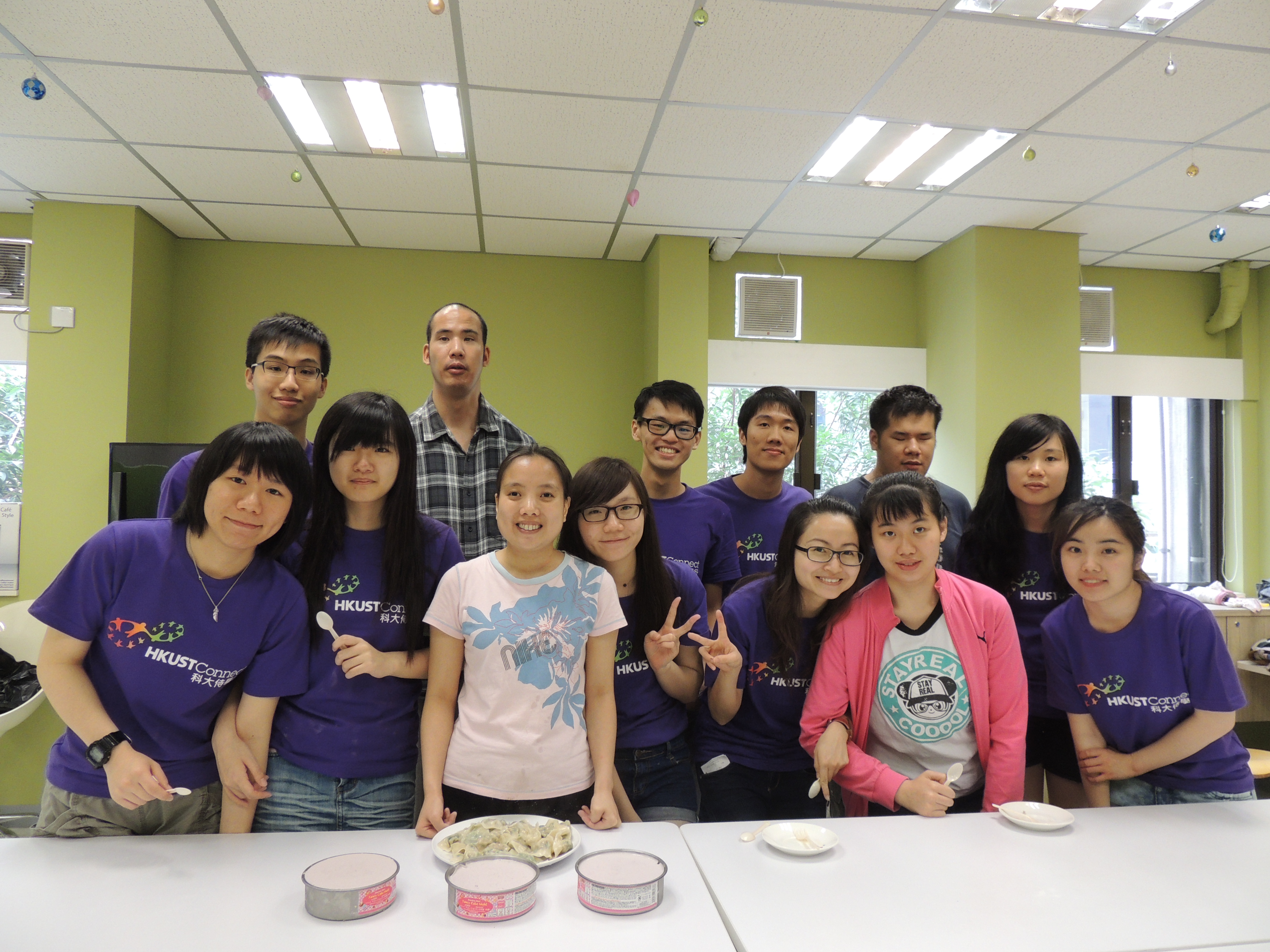 A group photo of volunteers and the service recipients with their handmade cheesecakes and dumplings