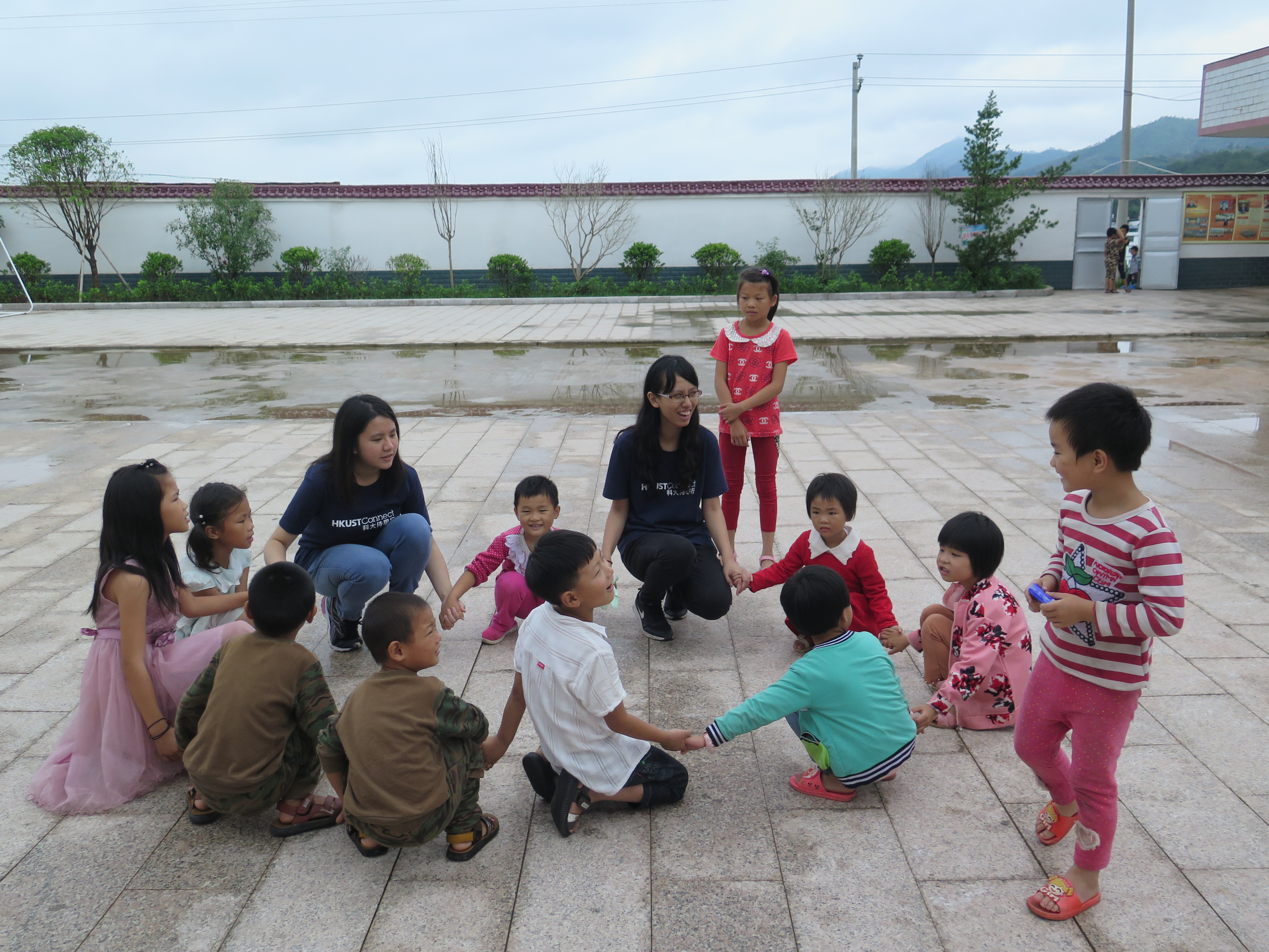 Volunteers and children in the village playing games together in the playground