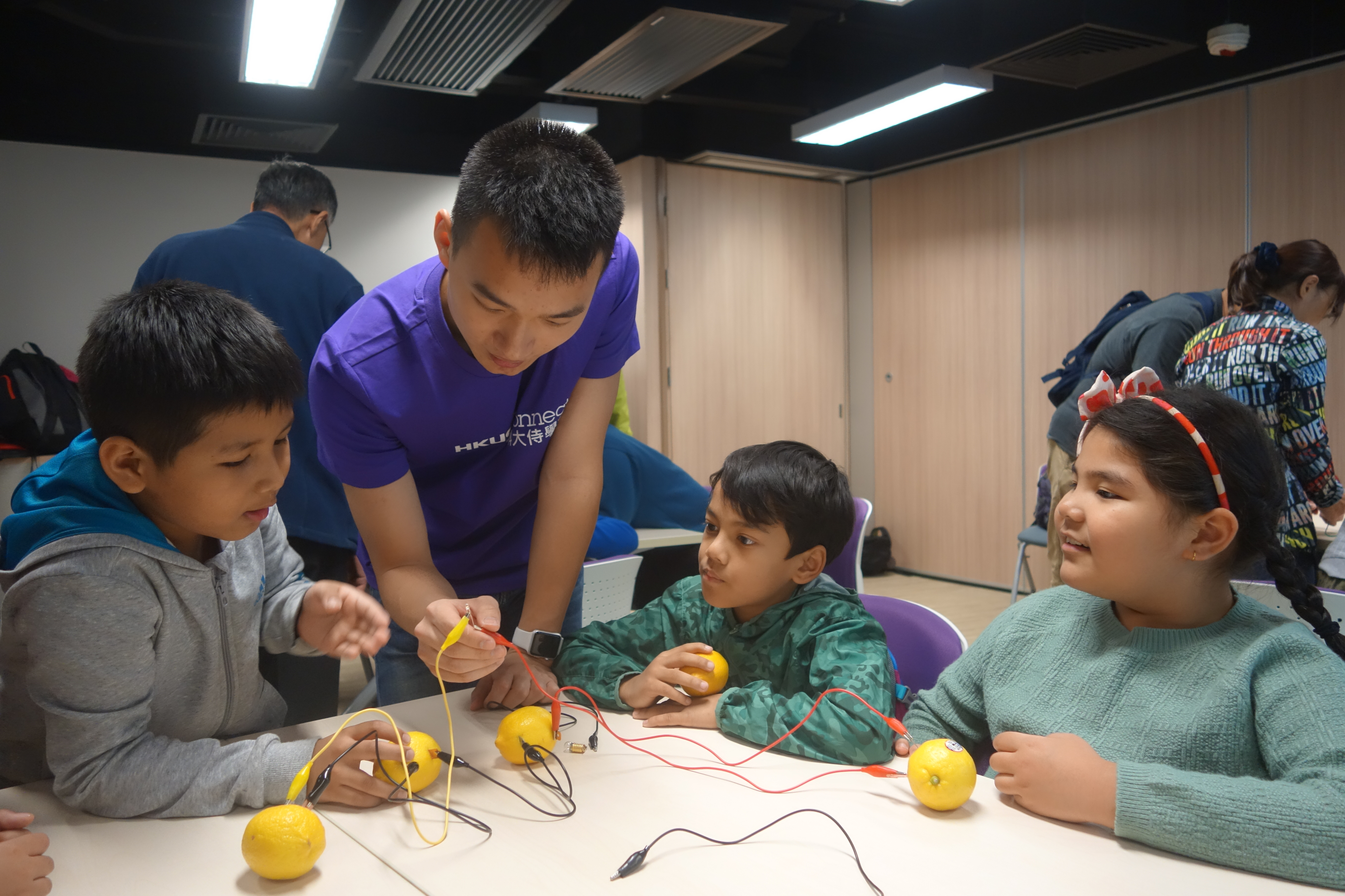 Volunteer guiding the kids to do an interesting experiment
