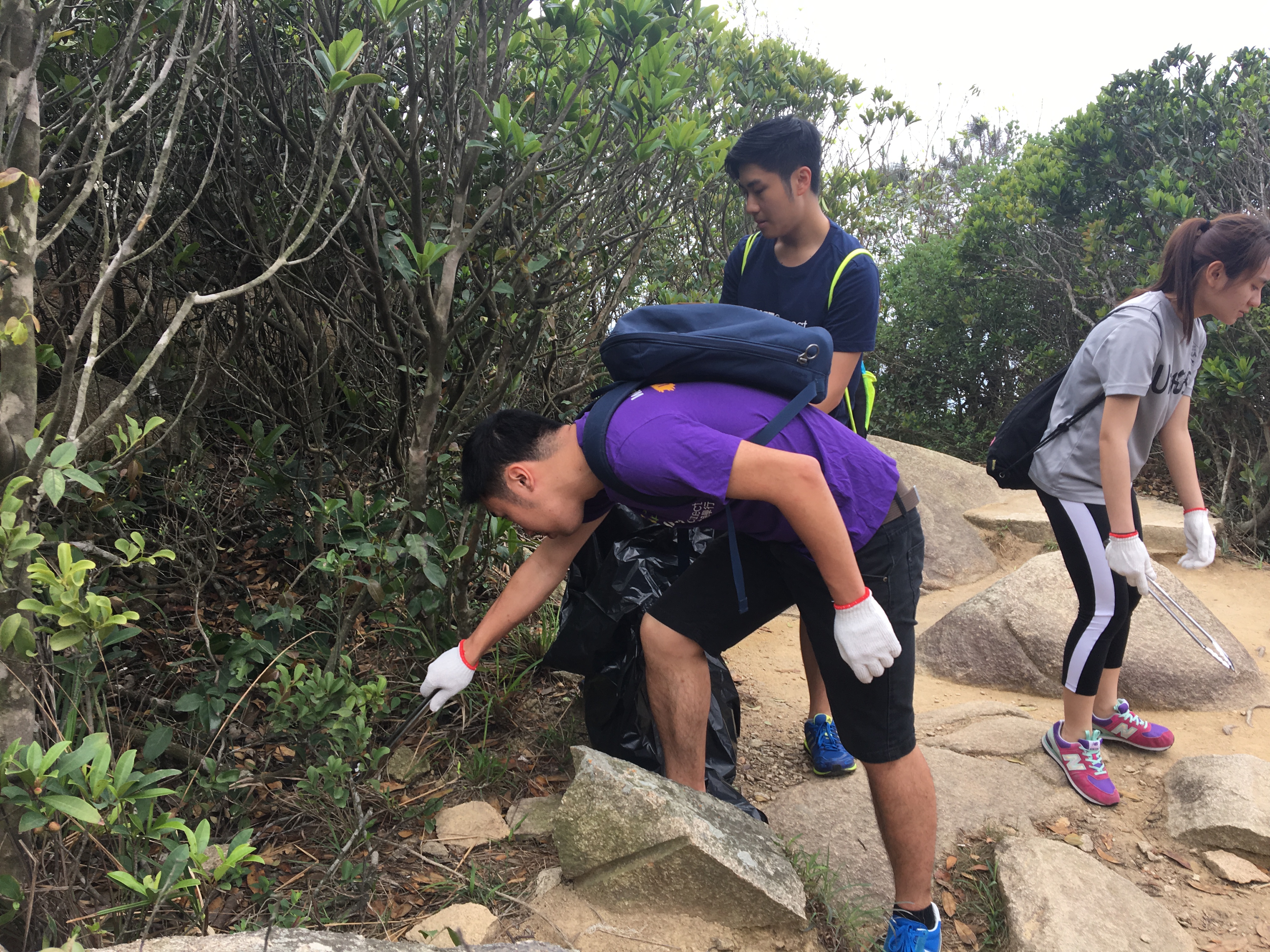 Volunteers picking up trash left by other hikers to keep the trail clean for everyone.