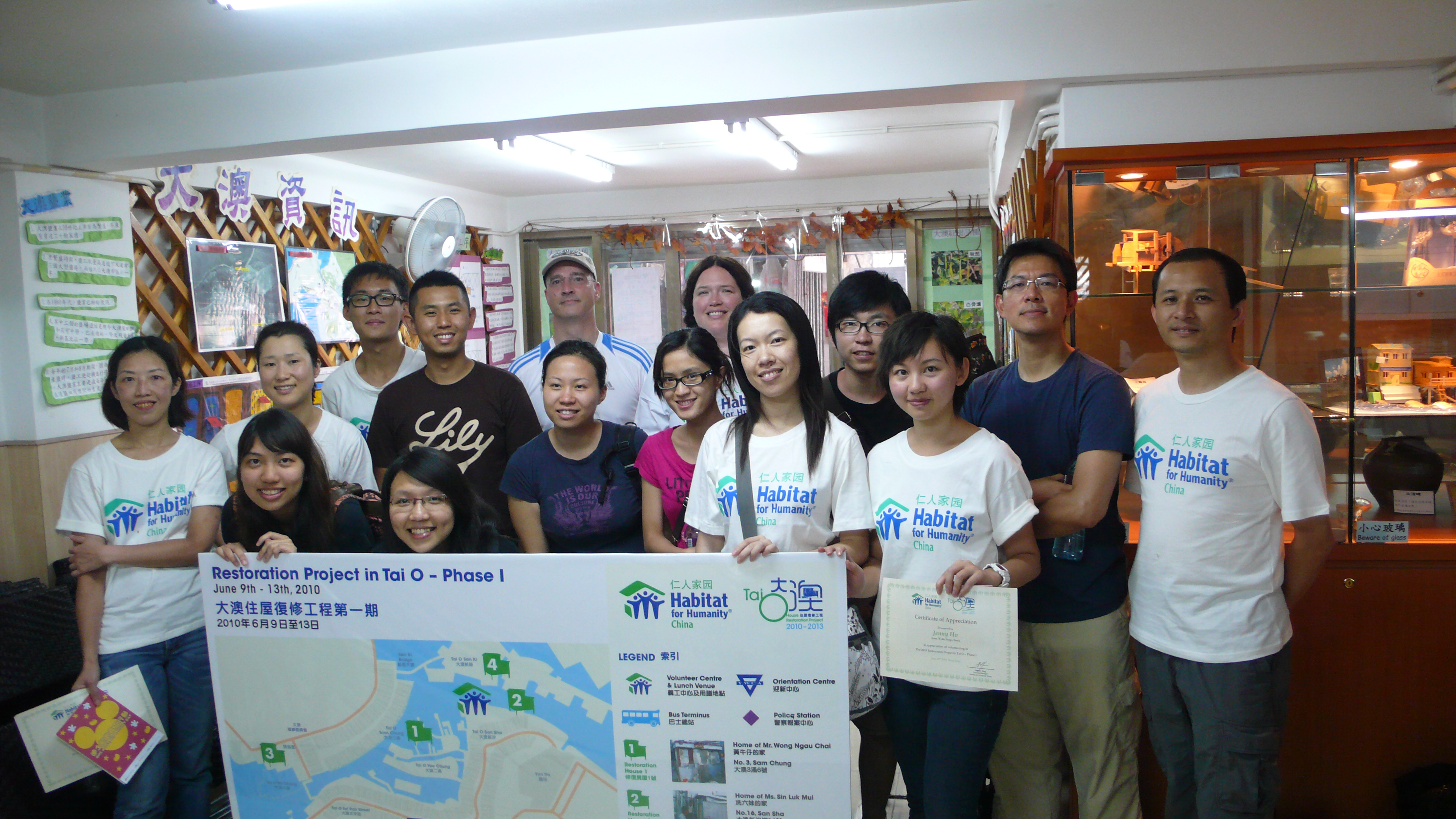 Students taking photos with other volunteers working on restoring the houses.