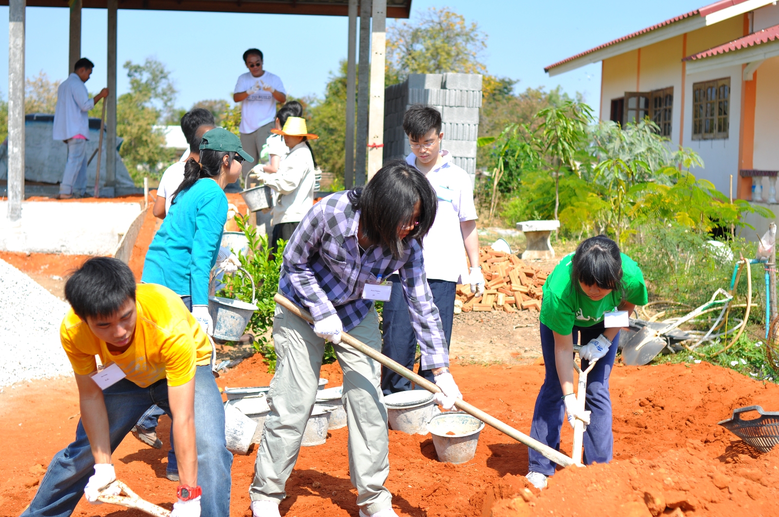 Student volunteers transferring soil into the house