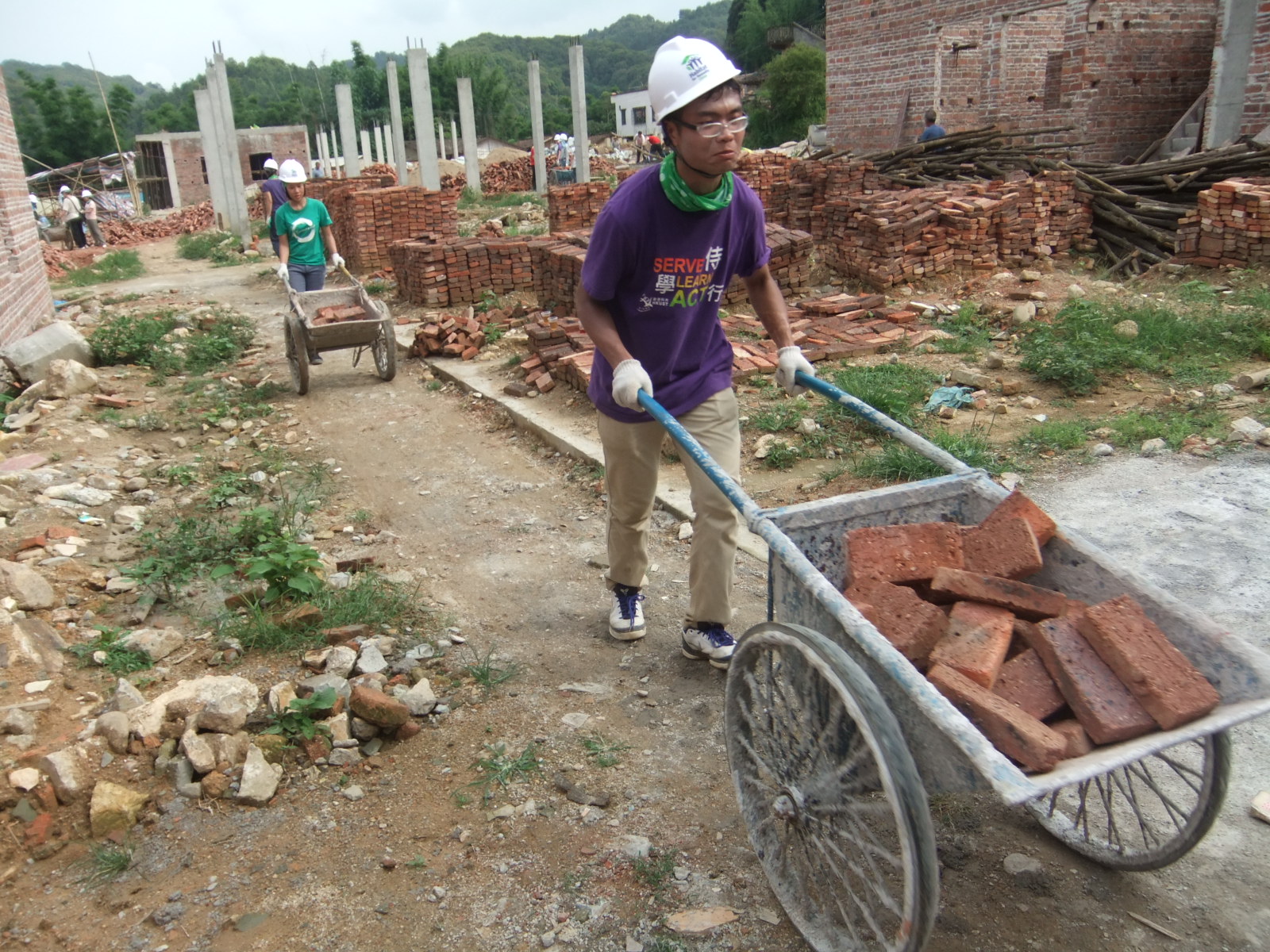 Student volunteers transferring bricks for the houses