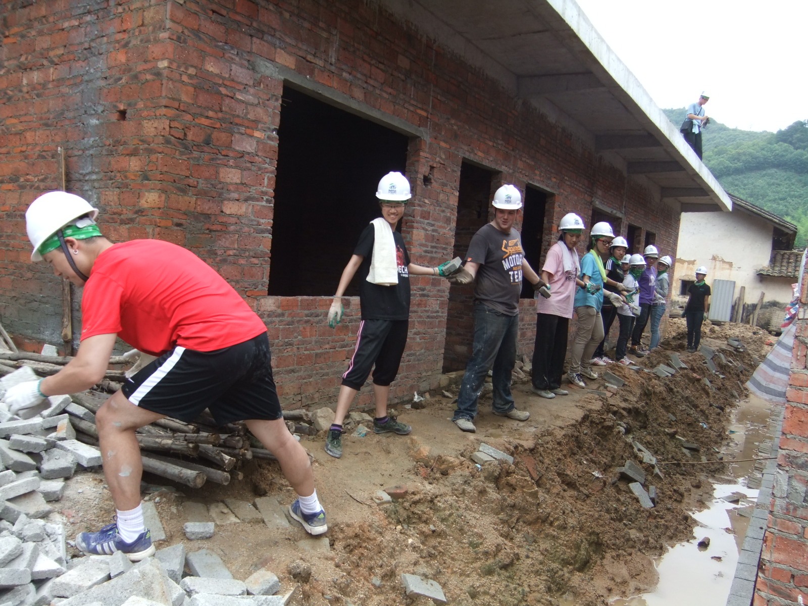 Students volunteers forming a human chain to pass bricks