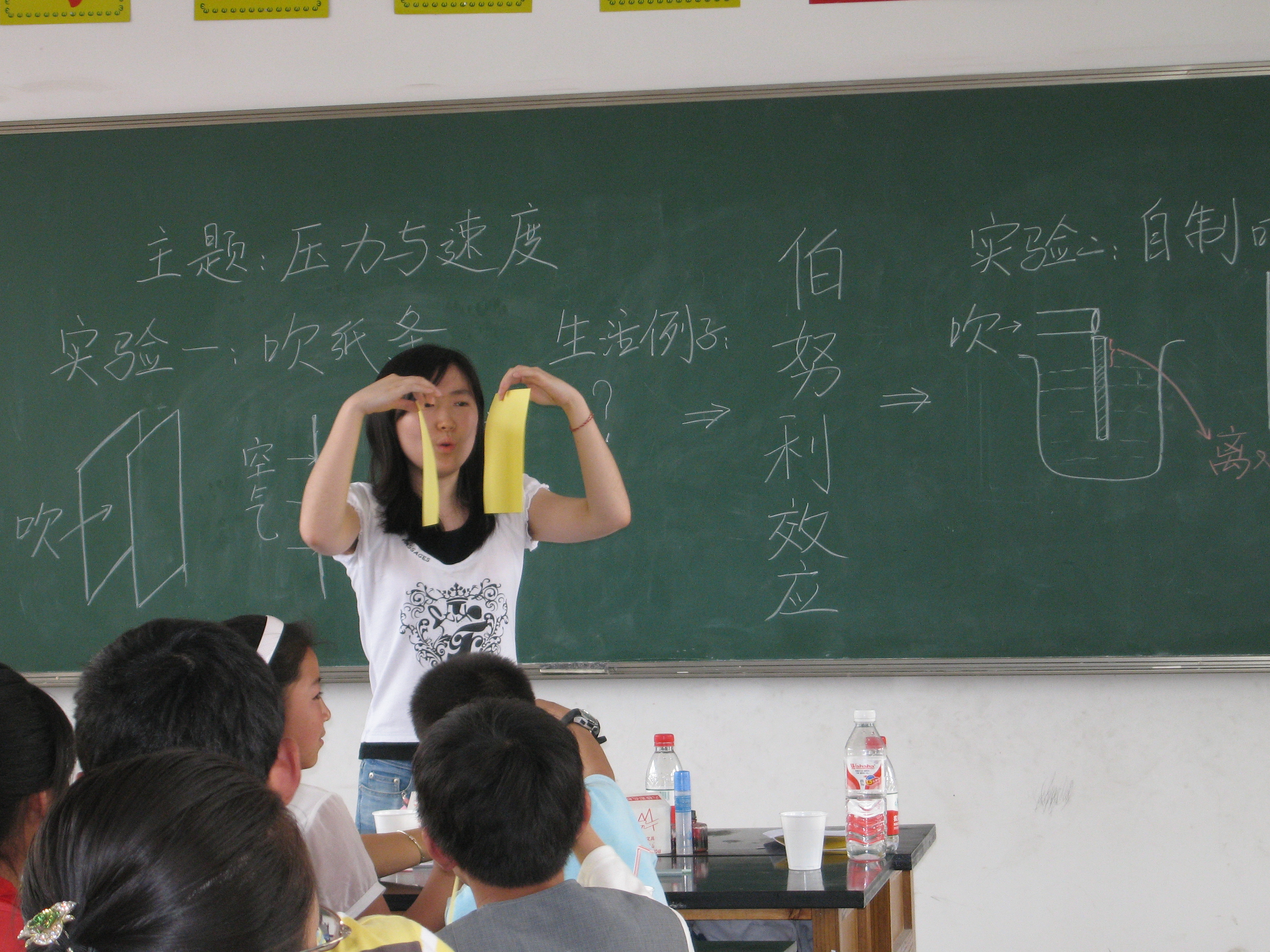 A student explaining science concepts to children through simple experiments