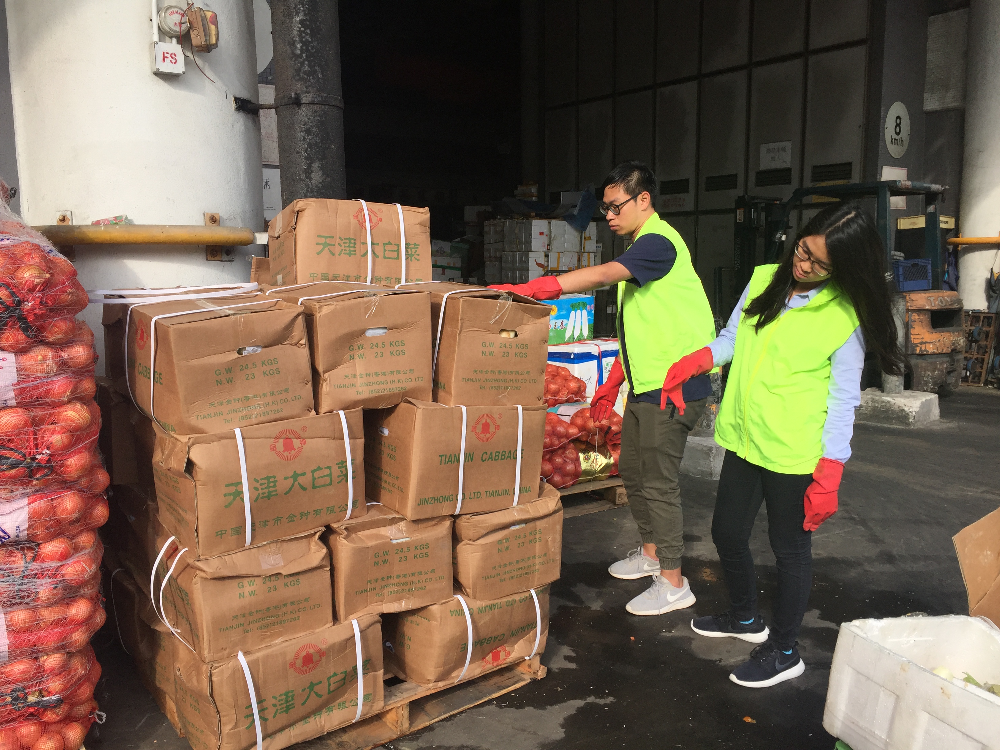 Volunteers estimating the number of boxes of unsold vegetables to be transported to the groups in need