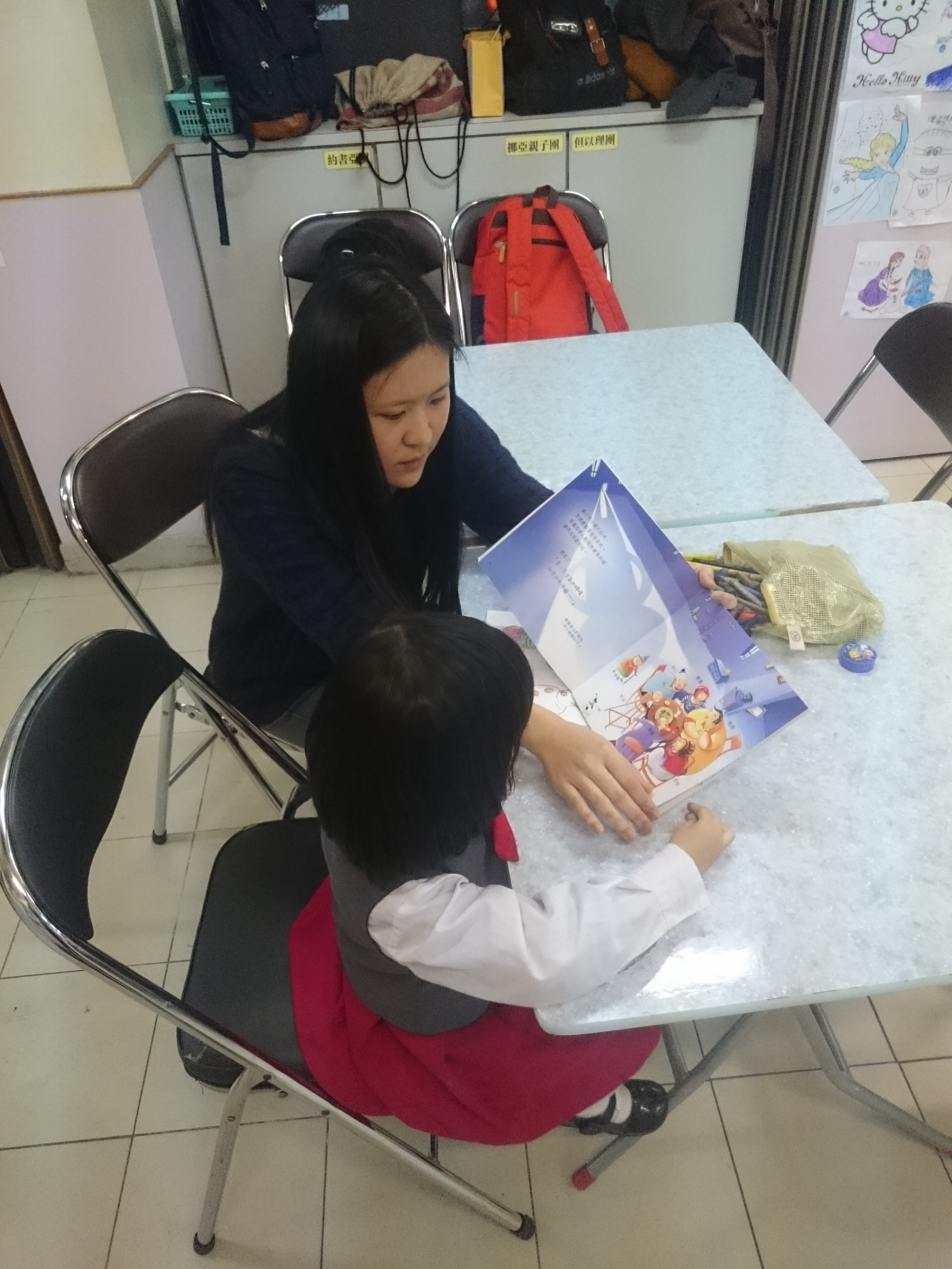 Volunteers reading story books with a child