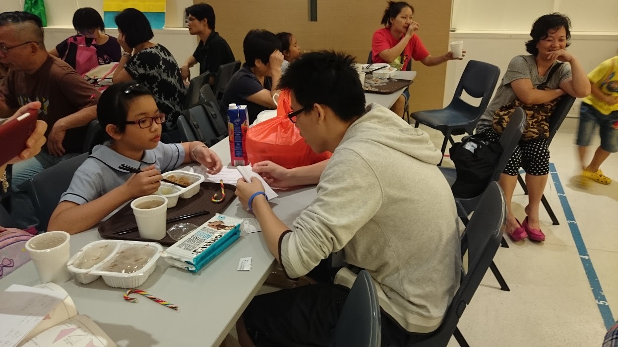 Volunteer chatting with the children during dinner