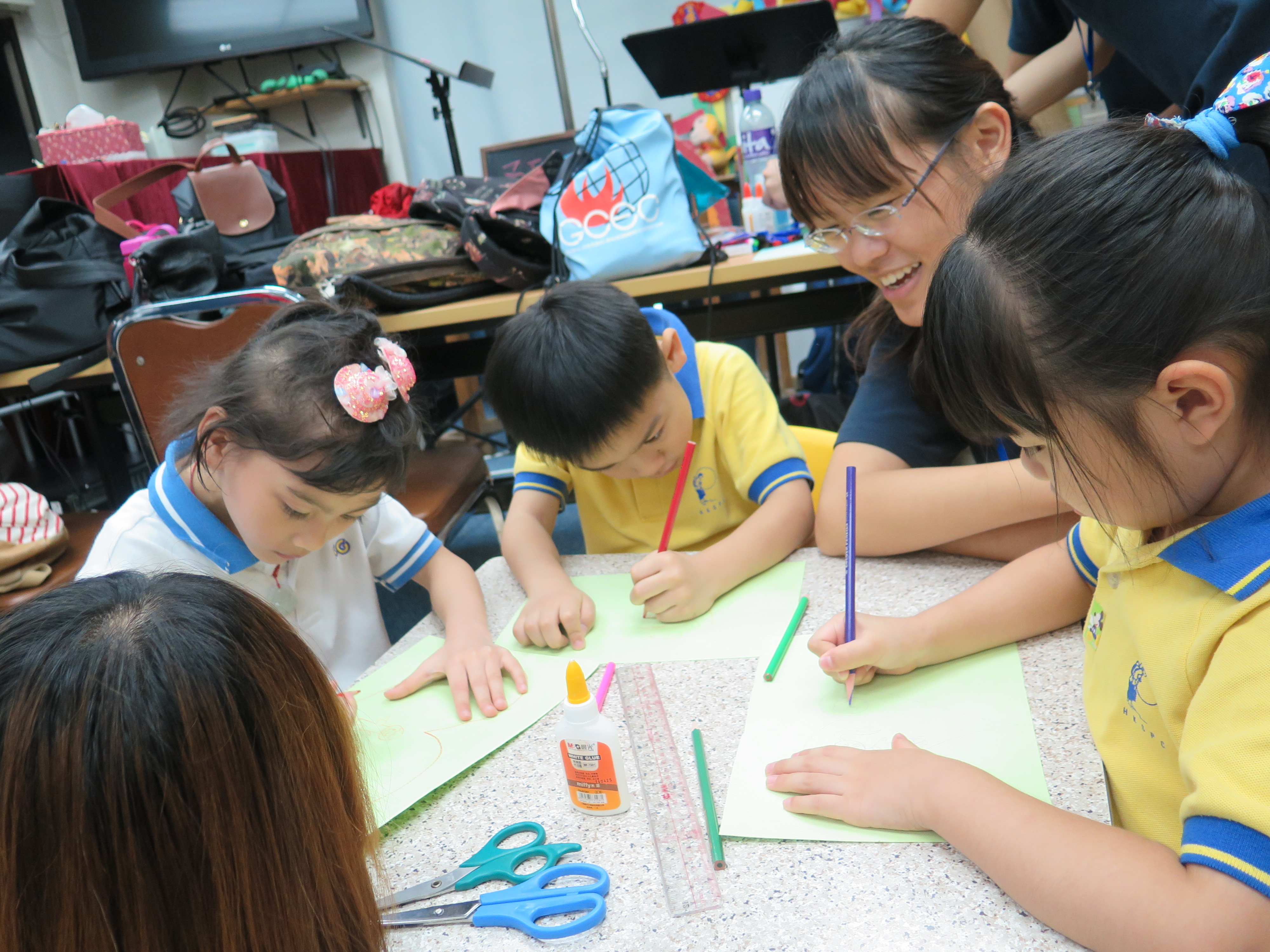 Assisting the children in Joyful Family Canteen to make a bookmark