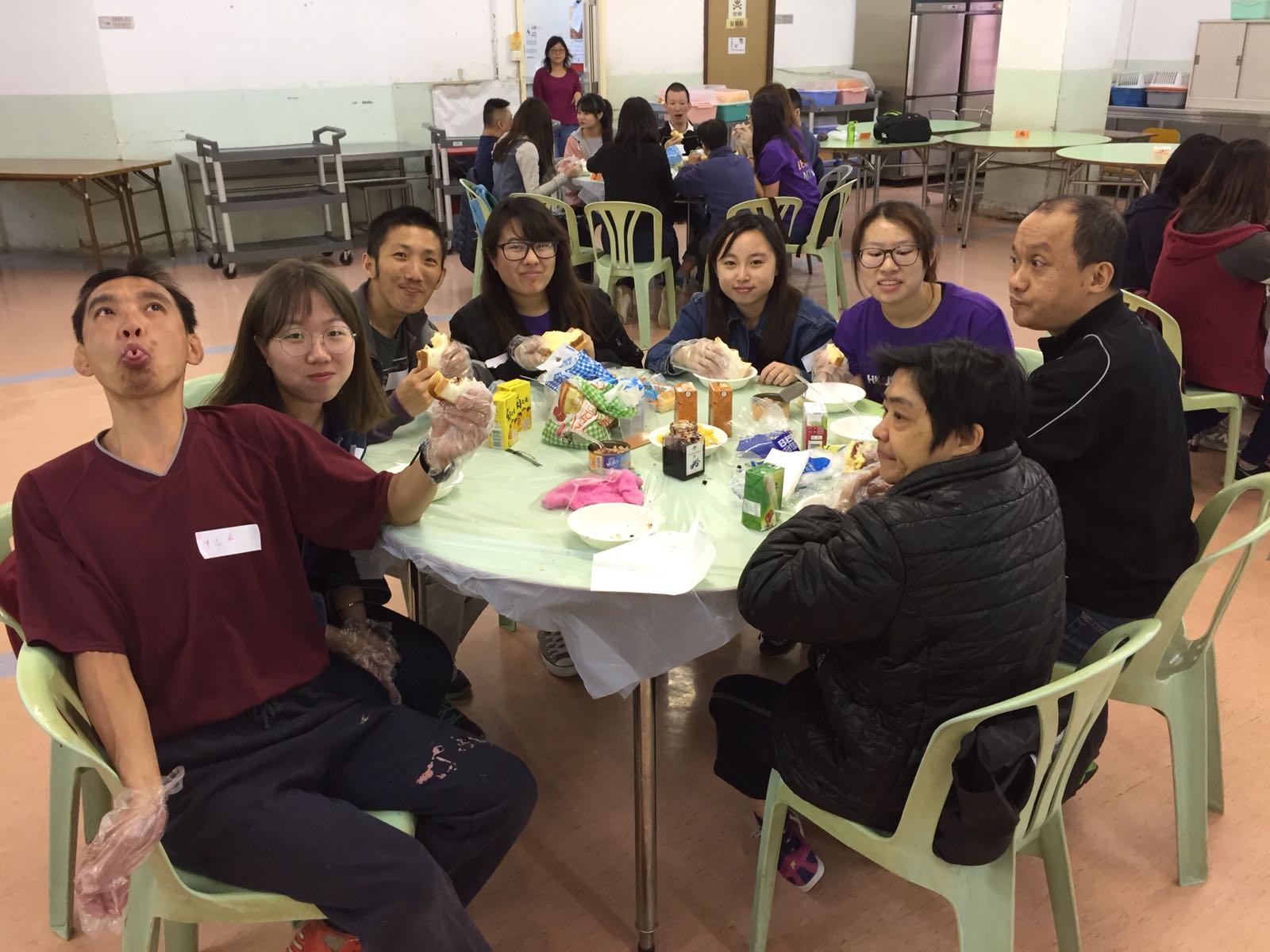 Volunteers and mentally challenged having refreshments together.