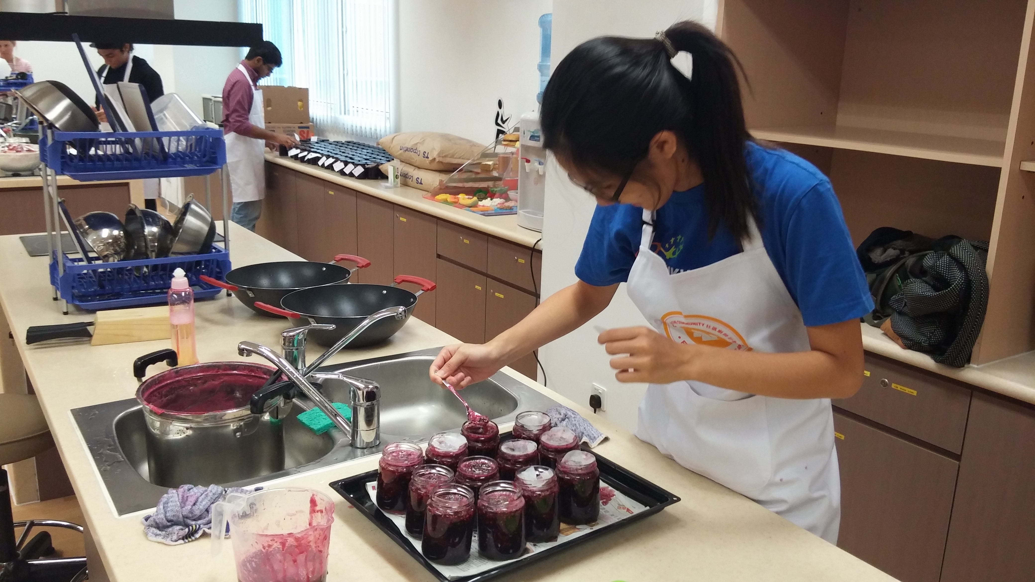 Carefully filling jars with fresh jam!
