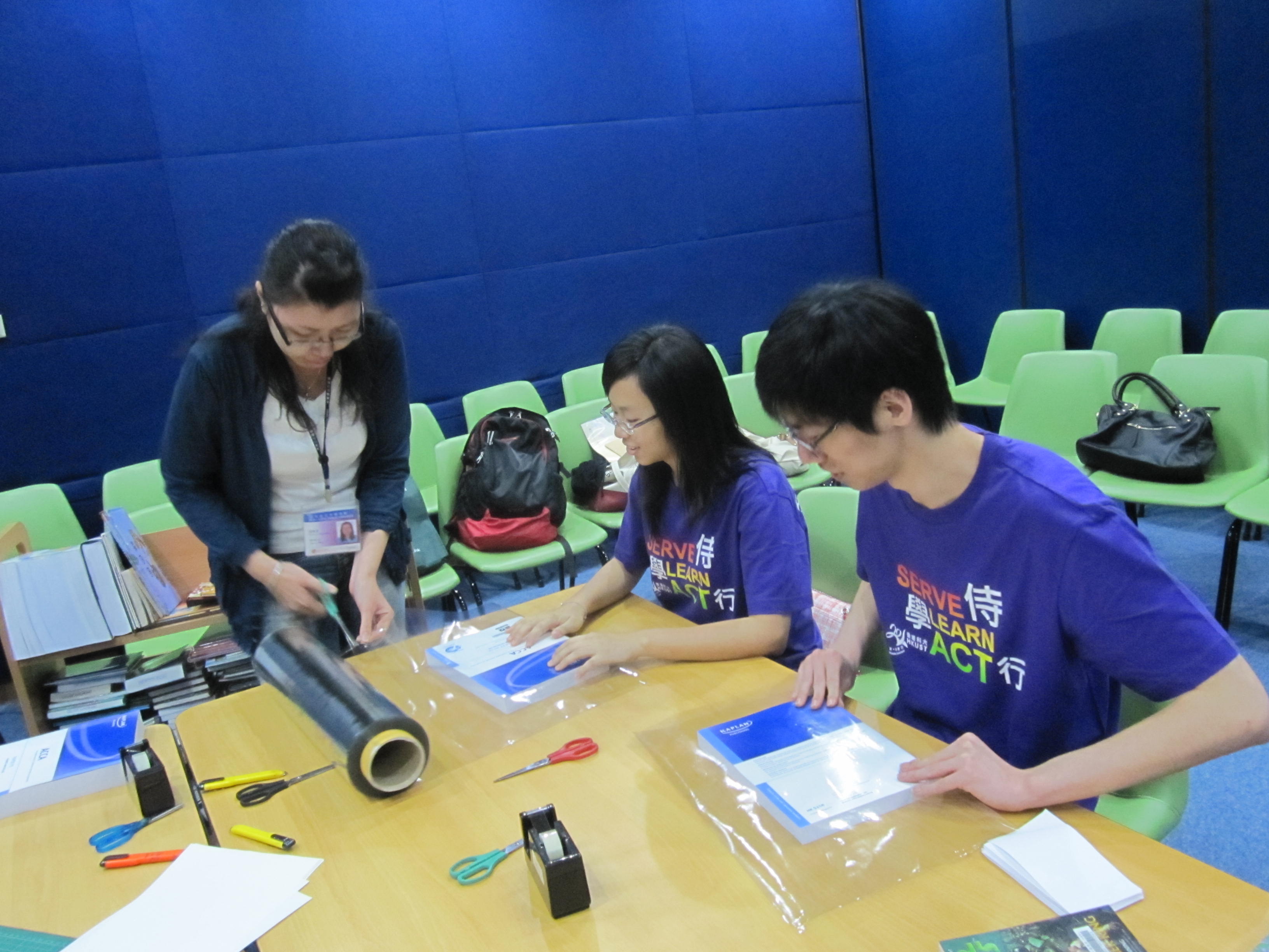 Volunteers learning how to wrap books