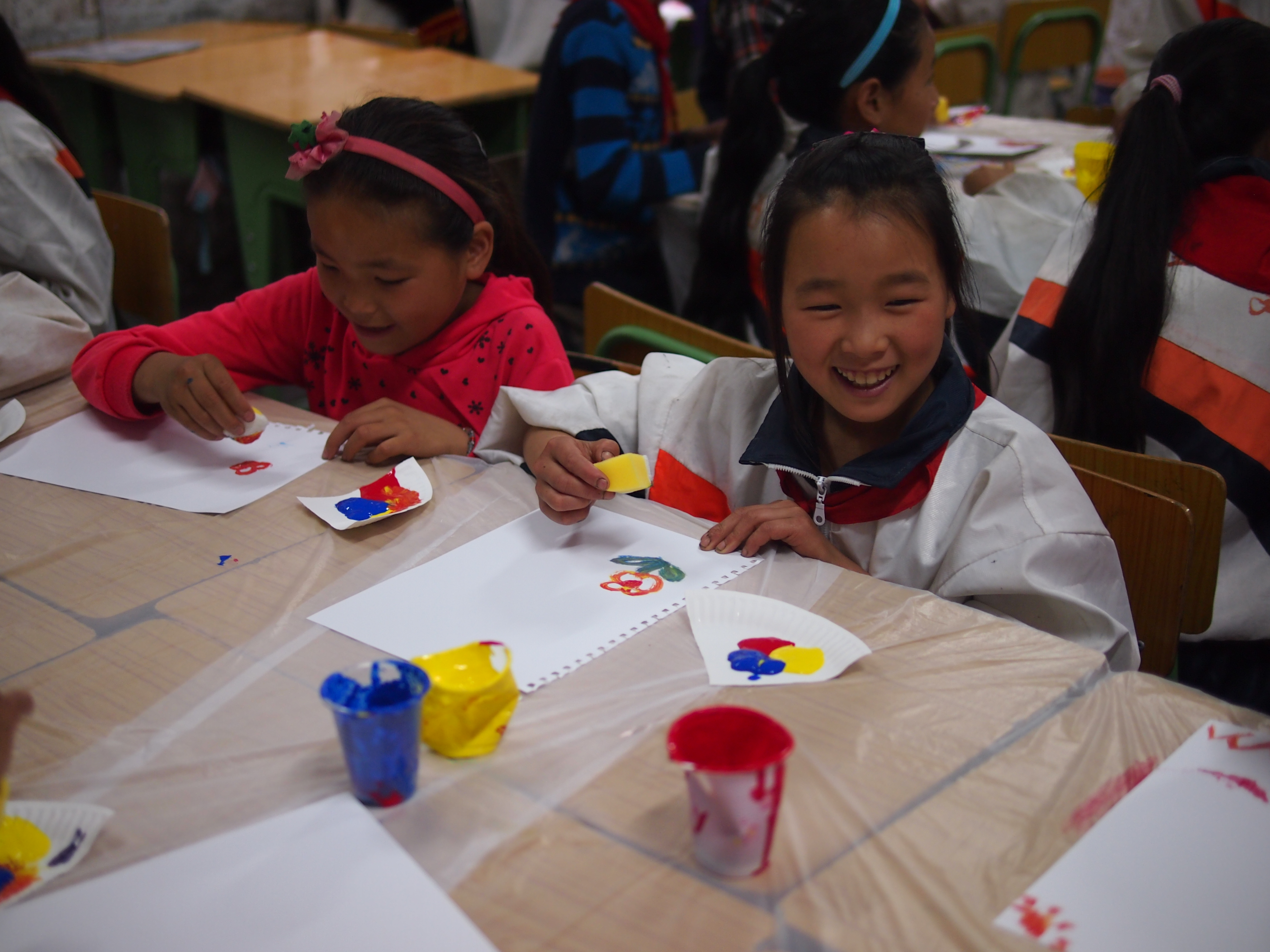 Children learning to draw a picture with sponge