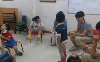 Volunteers playing games happily with the kids