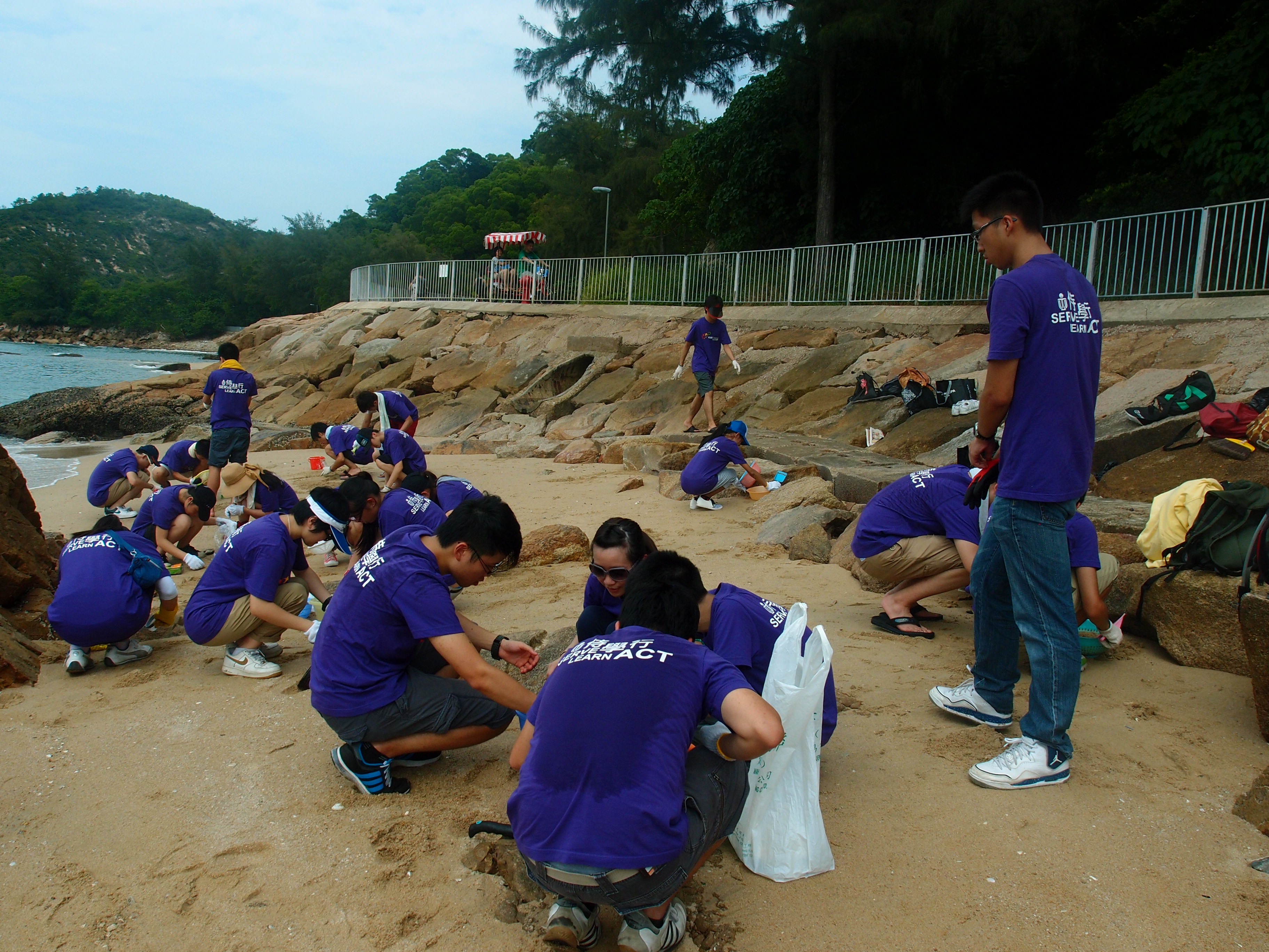Though sweating under the sunny weather, volunteers still concentrated on their cleaning work.
