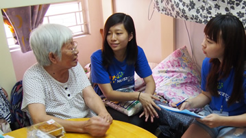 Our student volunteers chatting with the elder and giving a bag of rice
