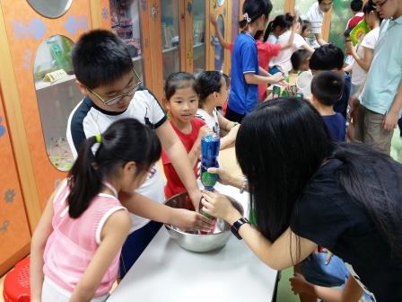 Volunteer facilitating children doing the experiment
