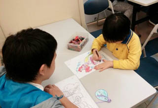 Volunteers teaching the children to draw picture