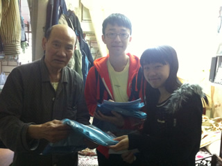 A pair of students visiting the elder with a gift