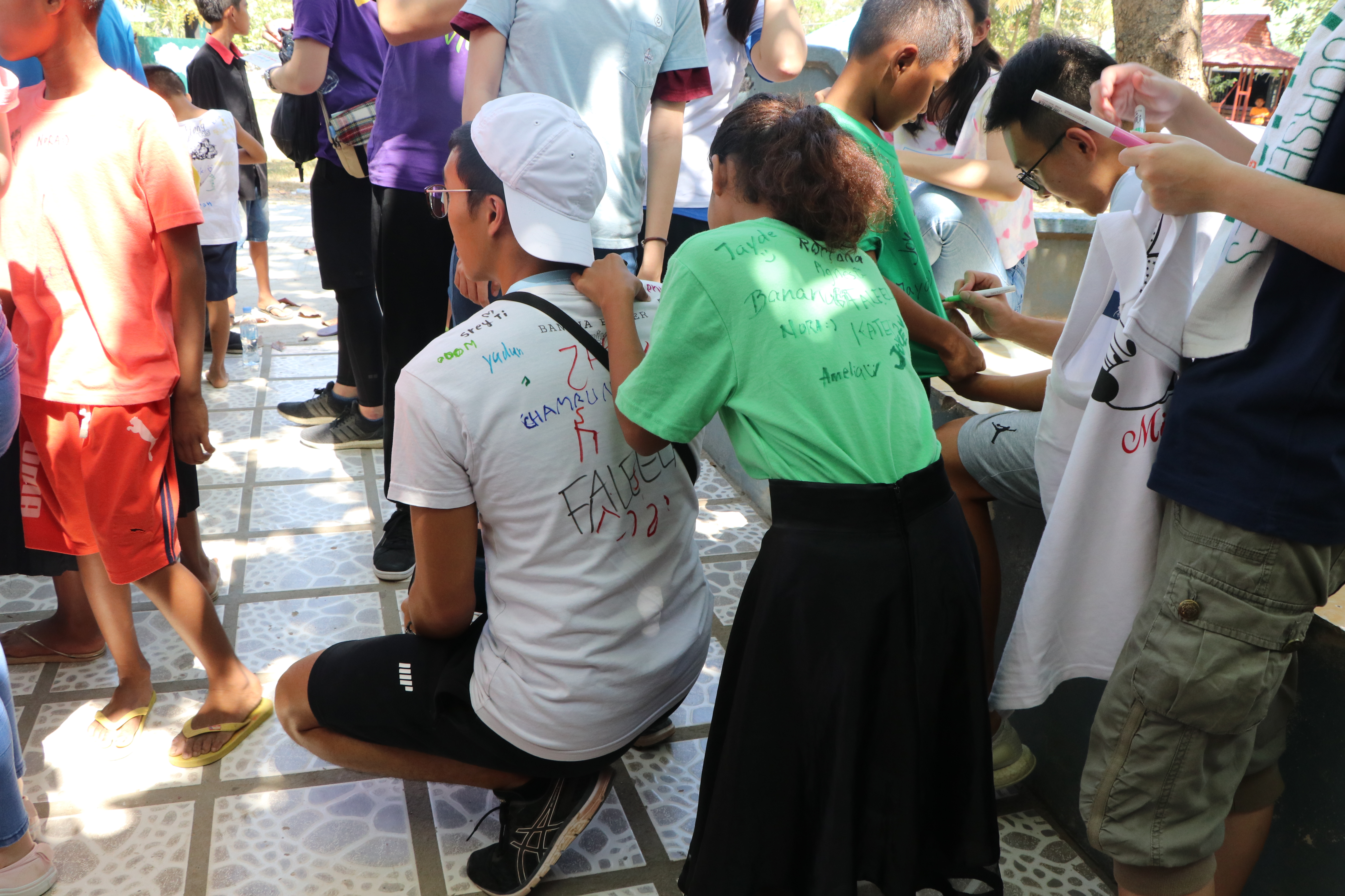 Kids in Wat Opot were writing names and drawing pictures on the backs of the volunteers.