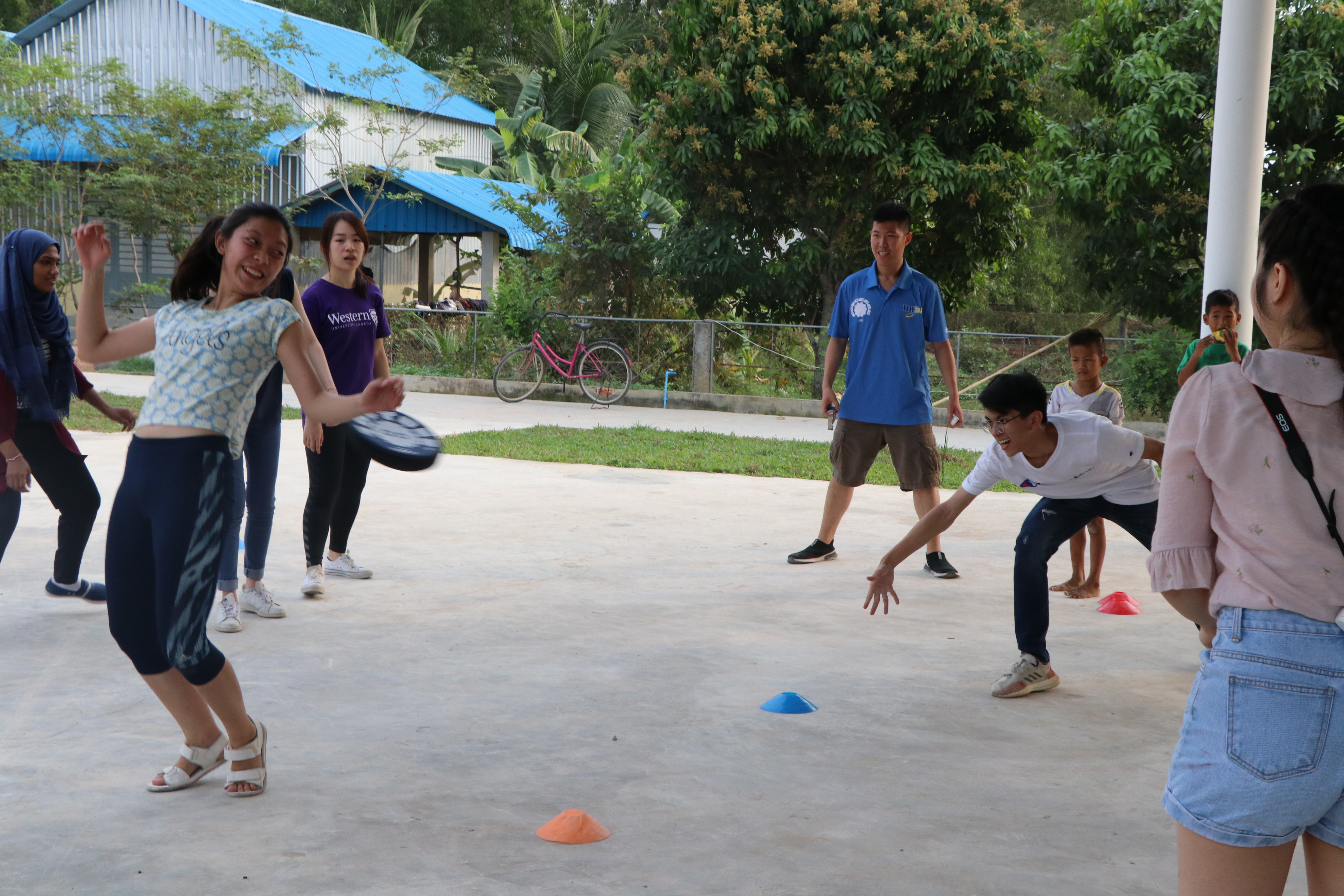 Both volunteers and kids learning how to play dodgebee, a new sport combining frisbee and dodgeball.