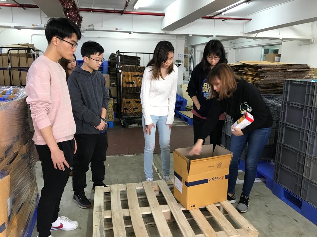 FHK staff took out two boxes and demonstrated the packing procedure with volunteers standing around her