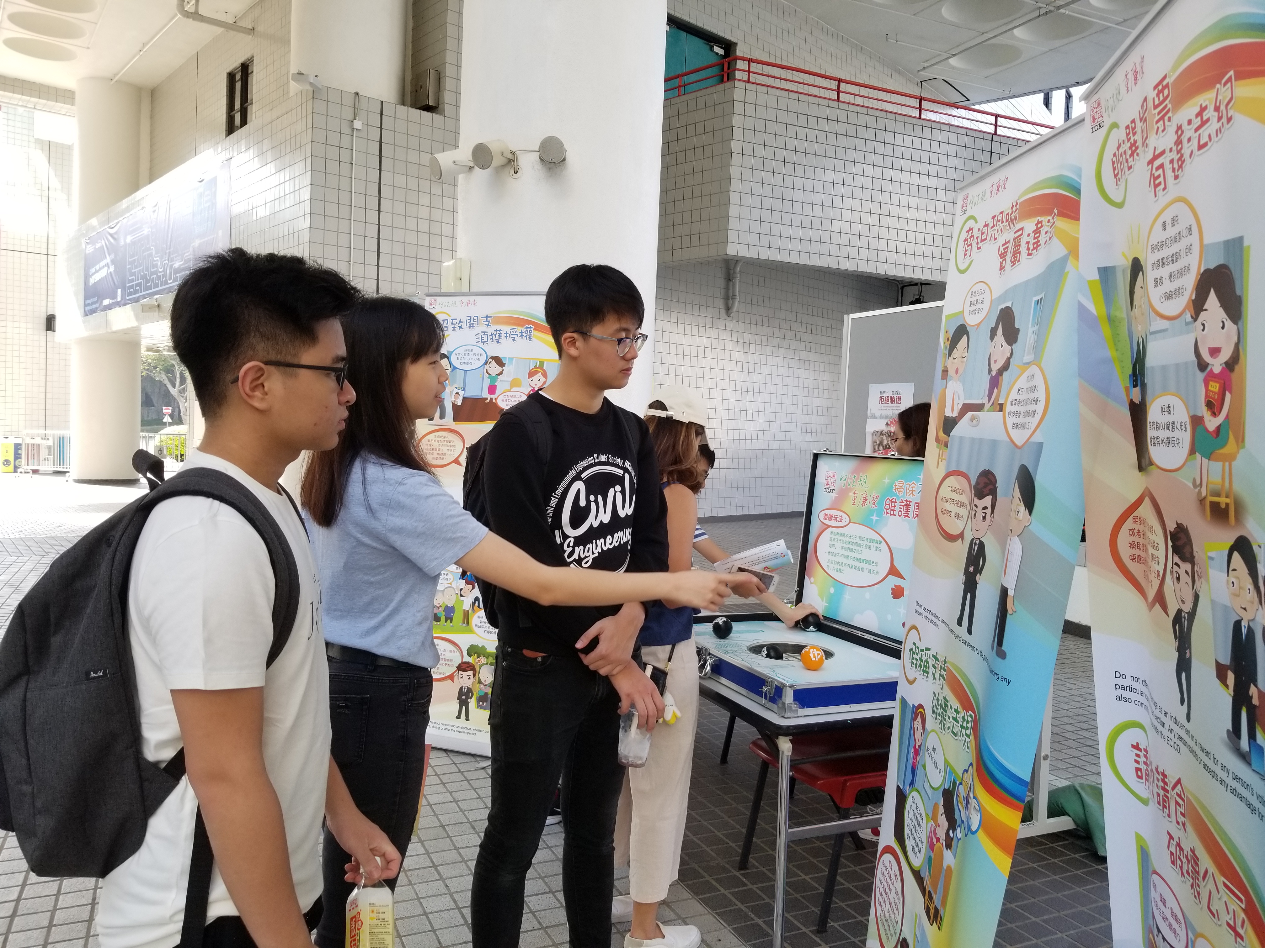 Volunteer shared short stories about election frauds in front of the vertical promotion stand.