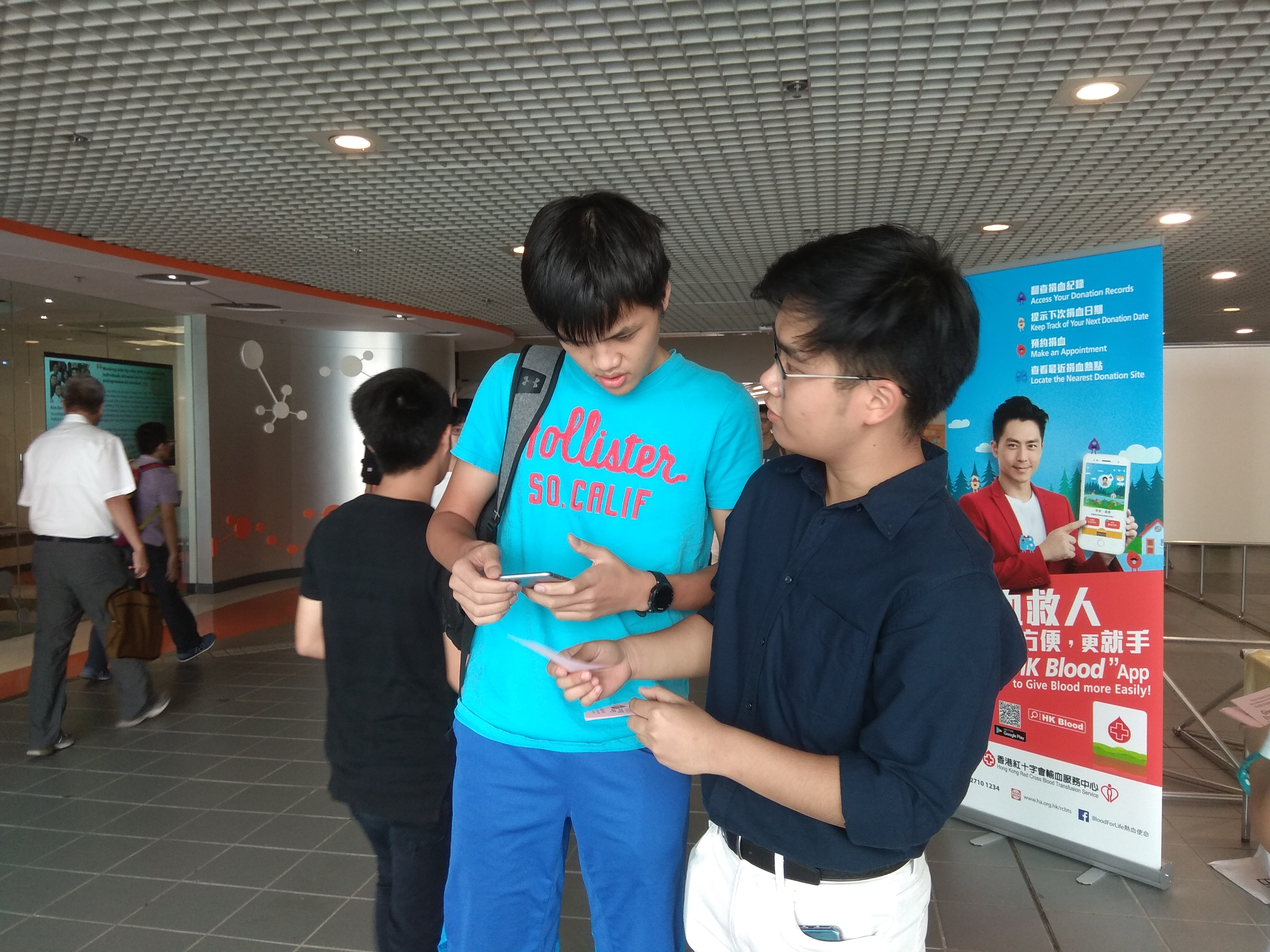 Volunteer is telling a student where he can donate blood on campus during the campaign period