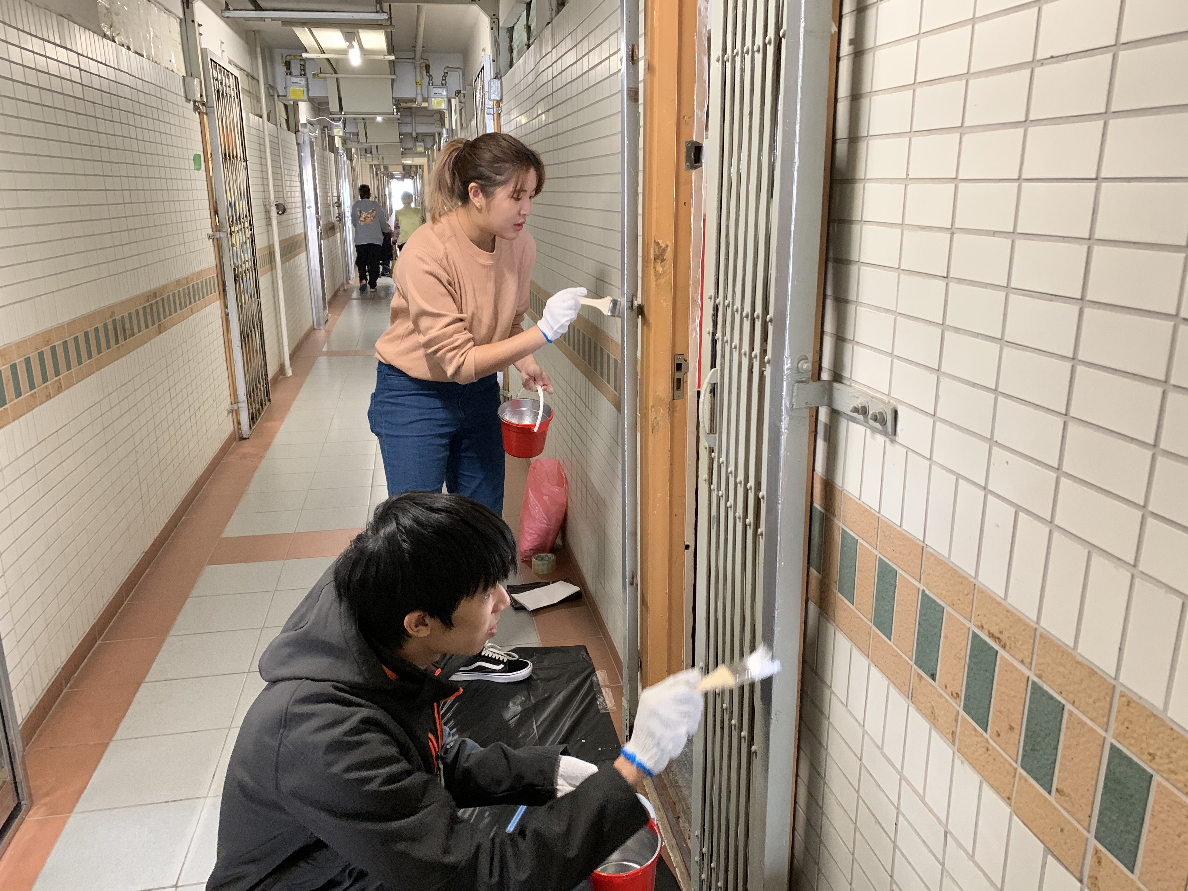 Volunteers painting metal gate of Moon Lok Dai Ha