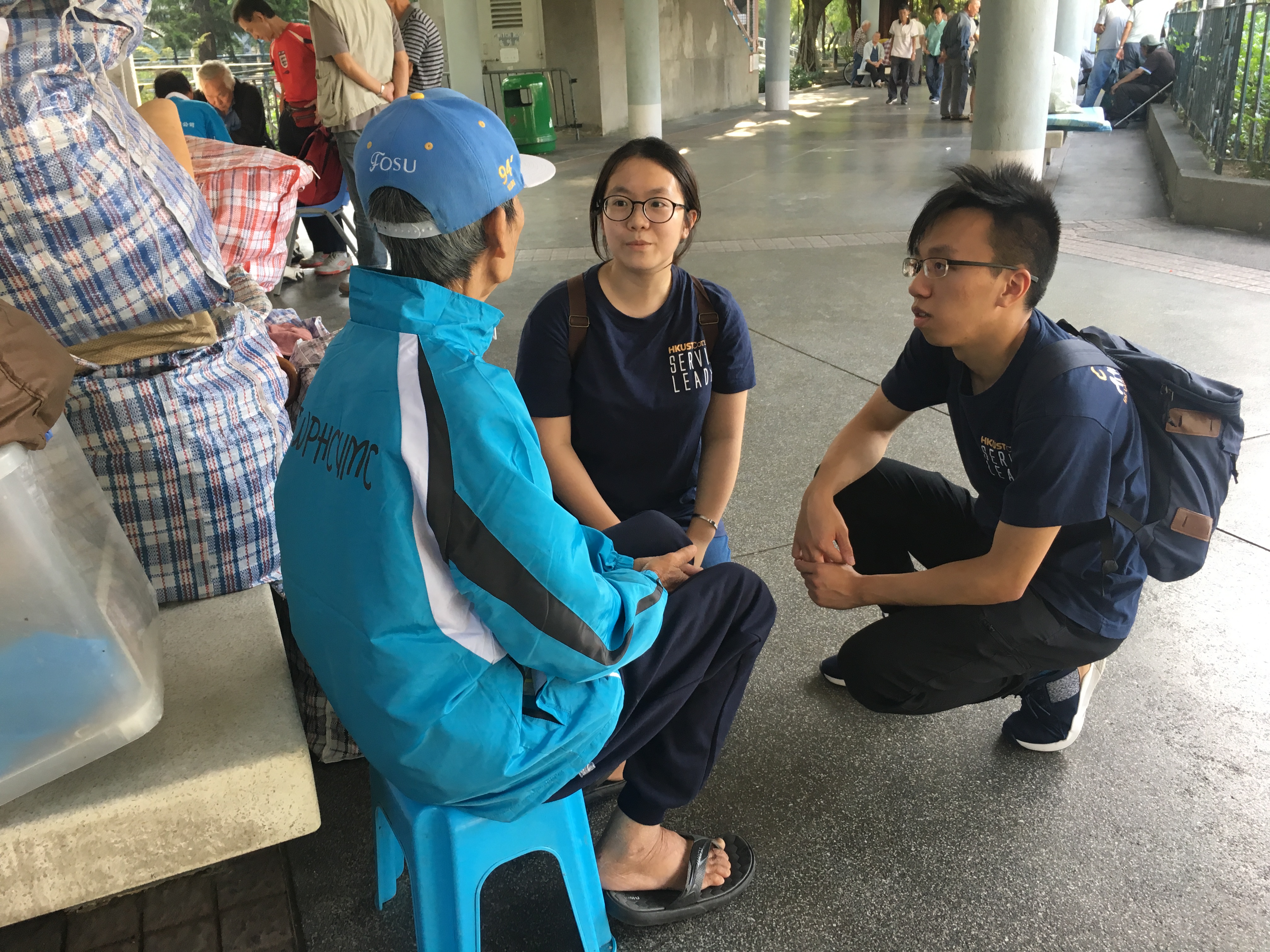 Volunteers chatting with street sleeper in a park