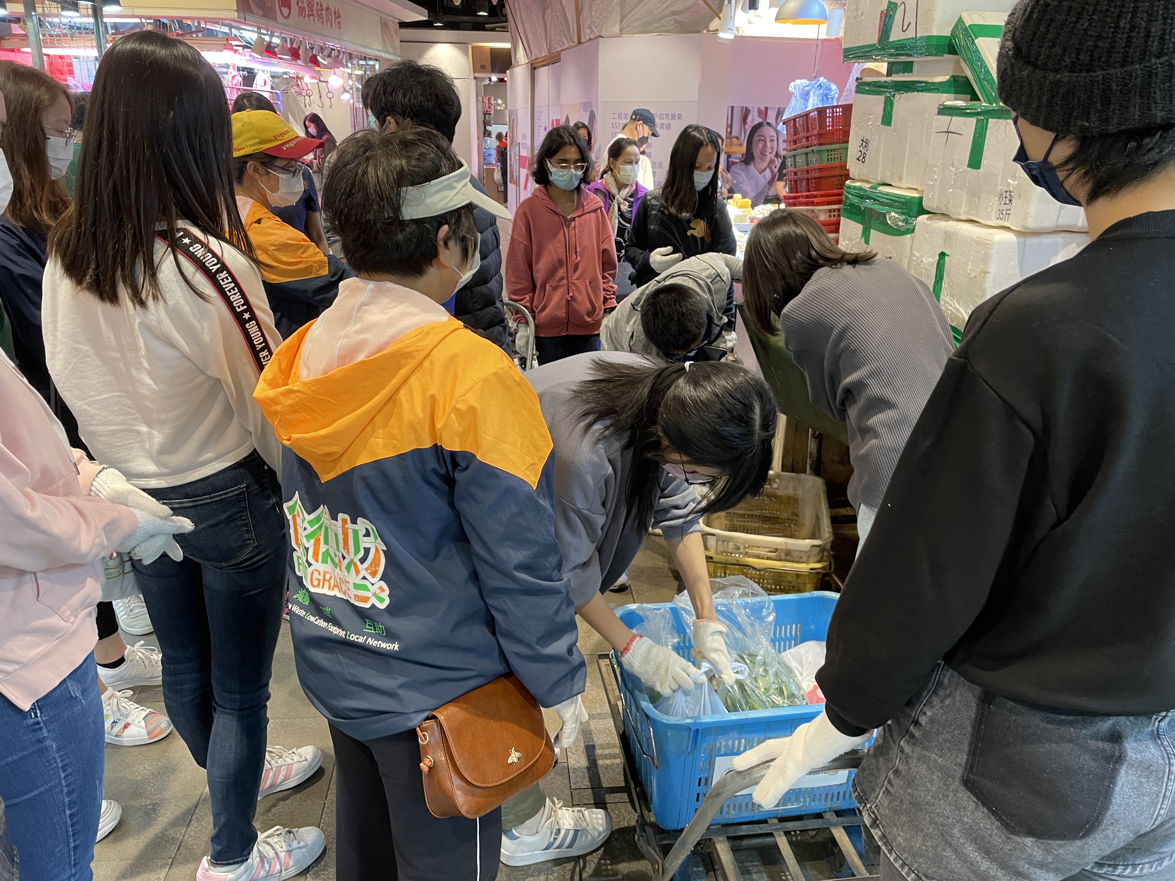 Volunteers are collecting food from the stalls in the wet market.