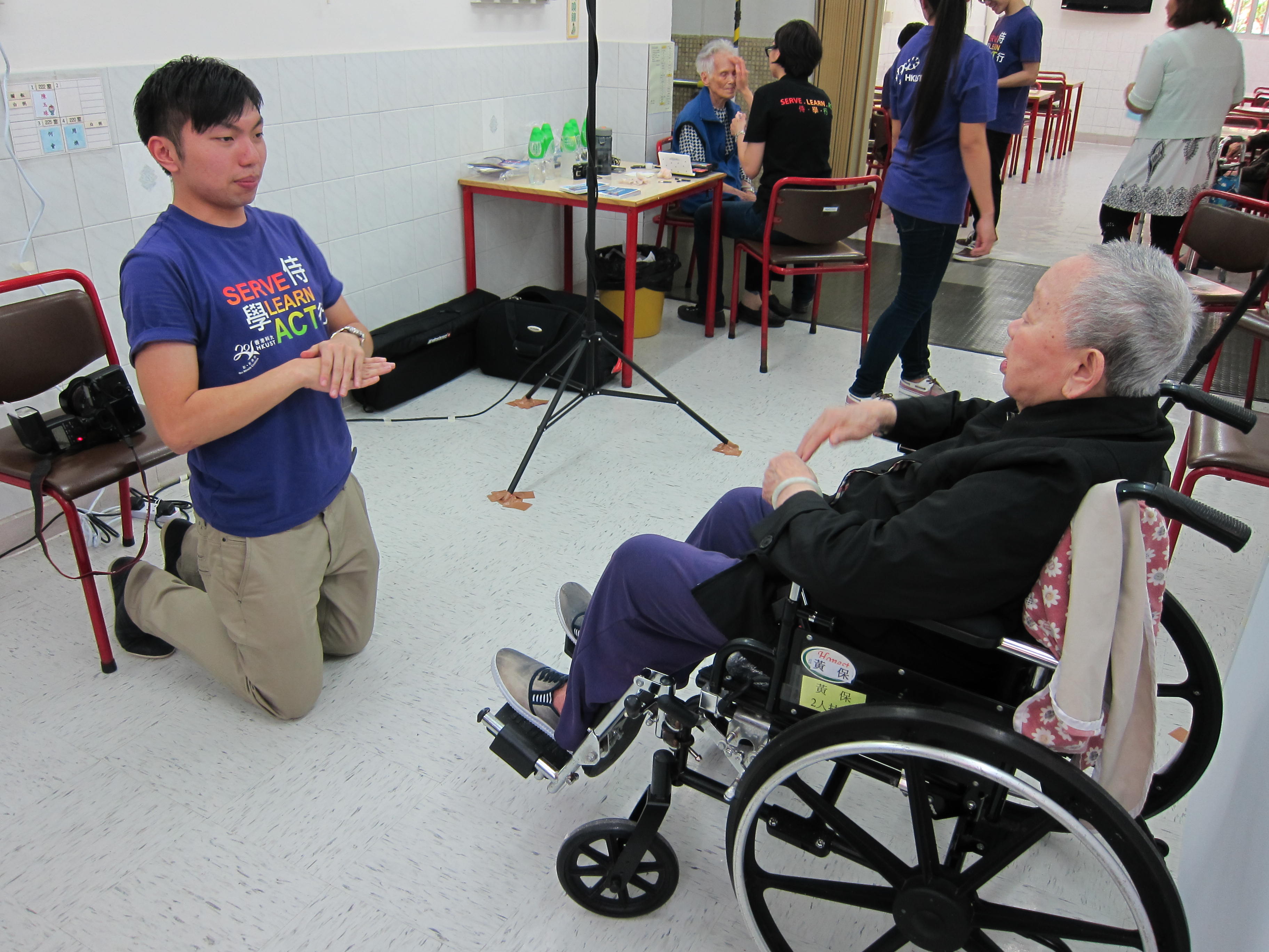 volunteer teaching elder on wheelchair how to pose