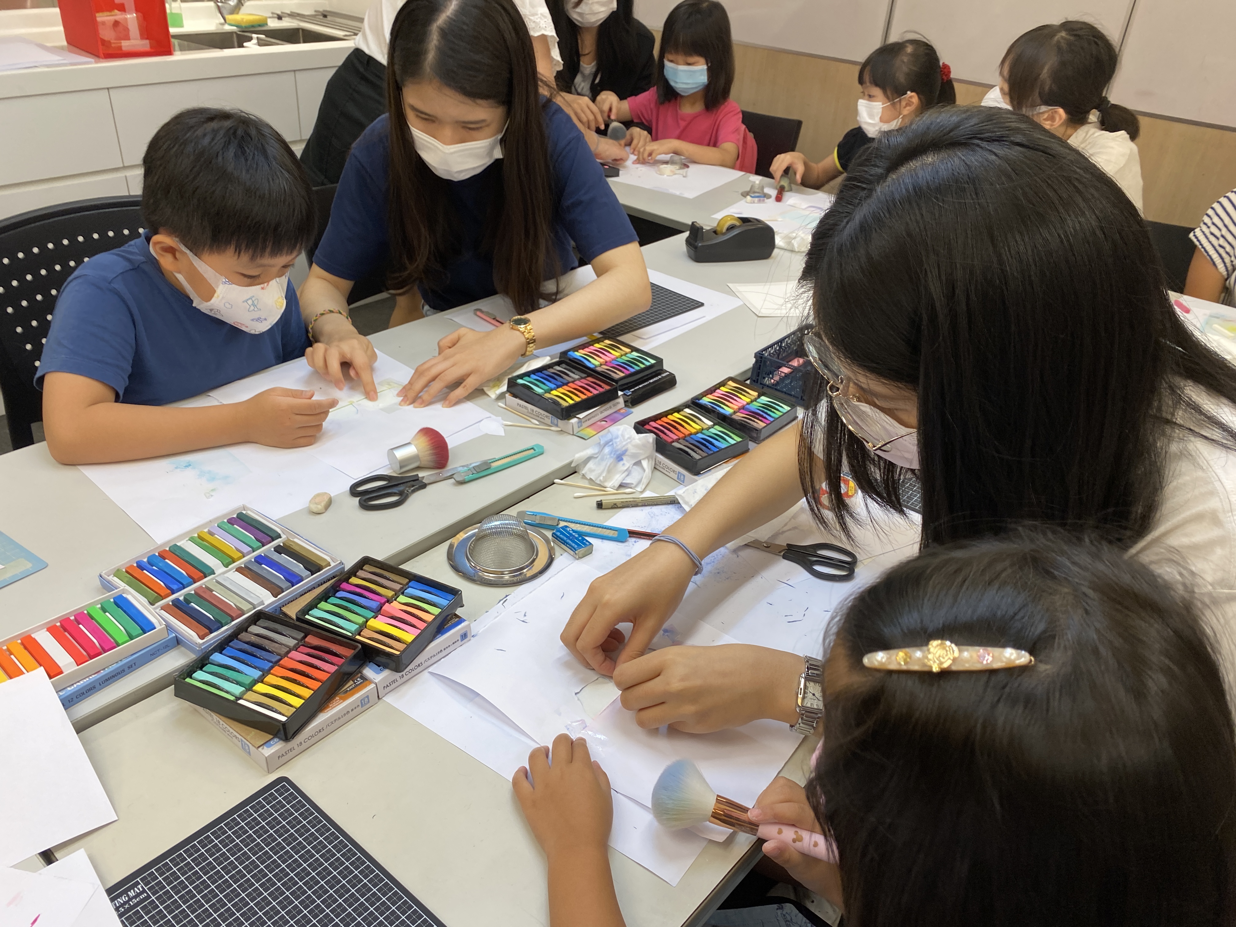 Volunteers teaching children how to make crafts