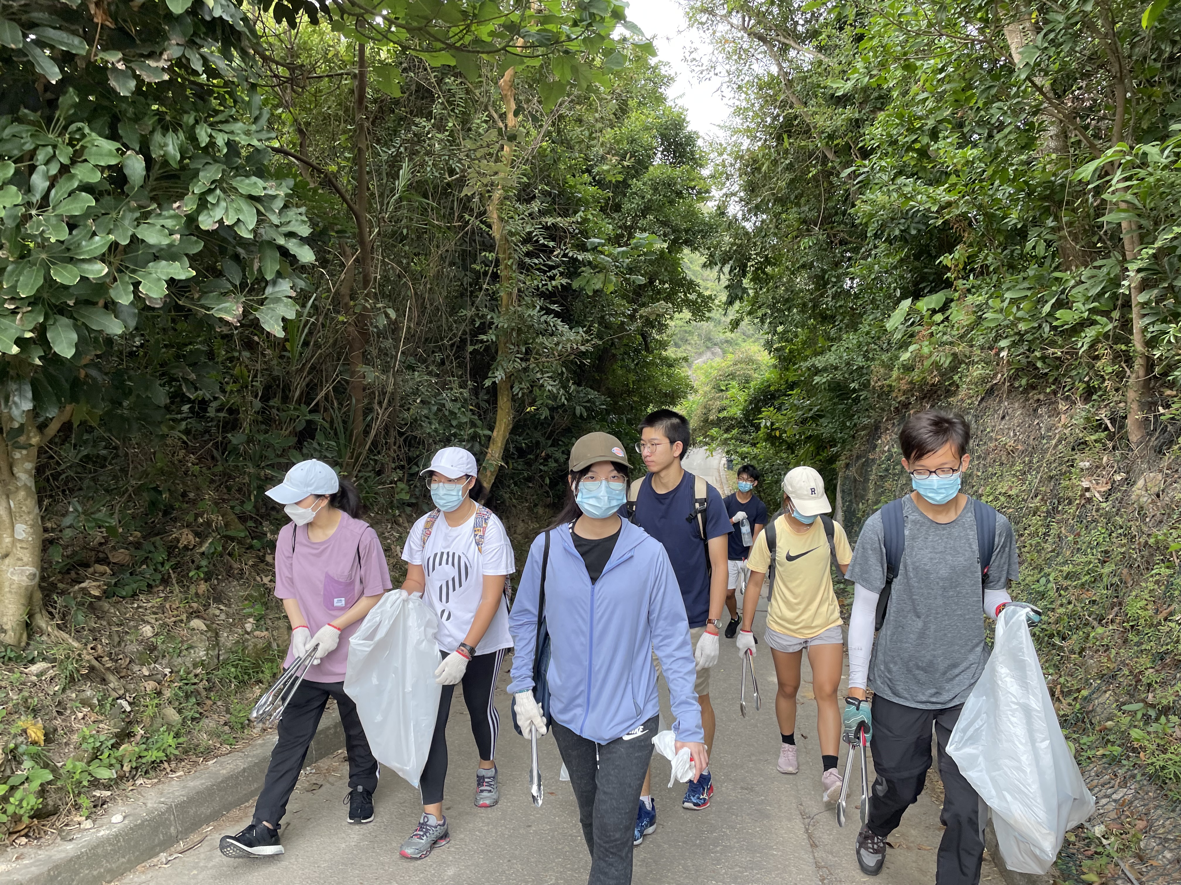 Volunteers actively scanning for trash along the trail