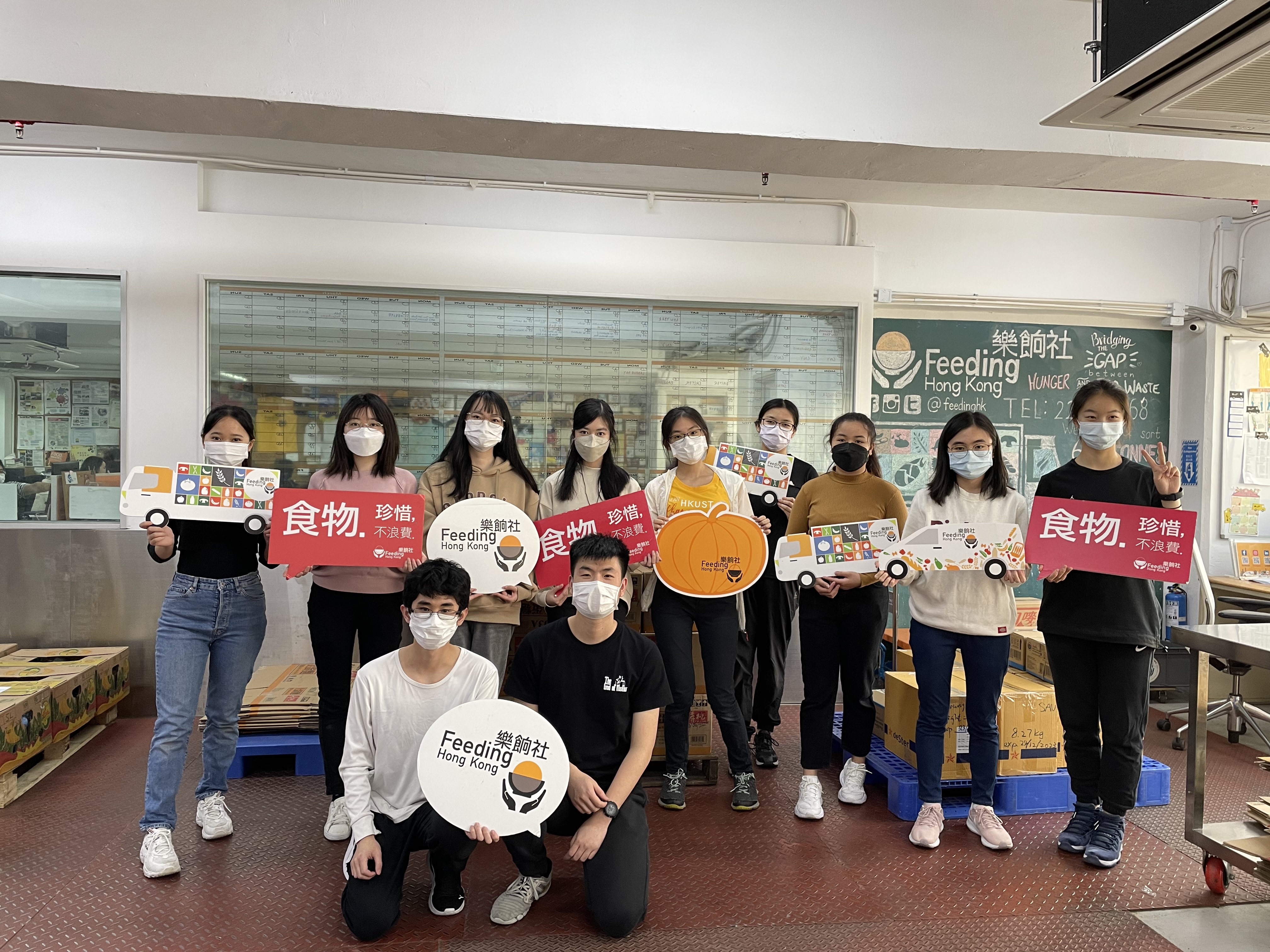 Group photo of volunteers with props in hand