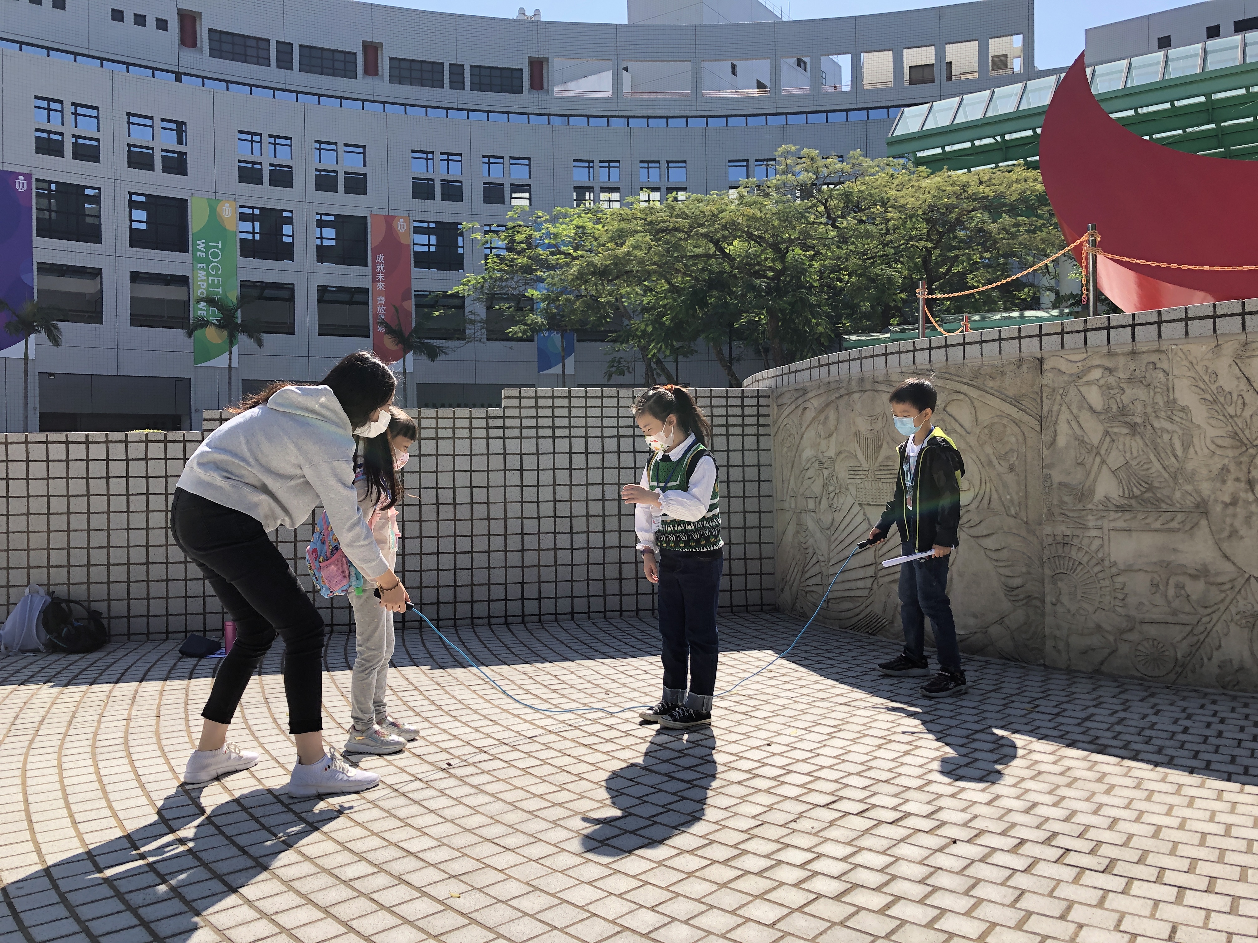 Kids playing games with an HKUST student on campus