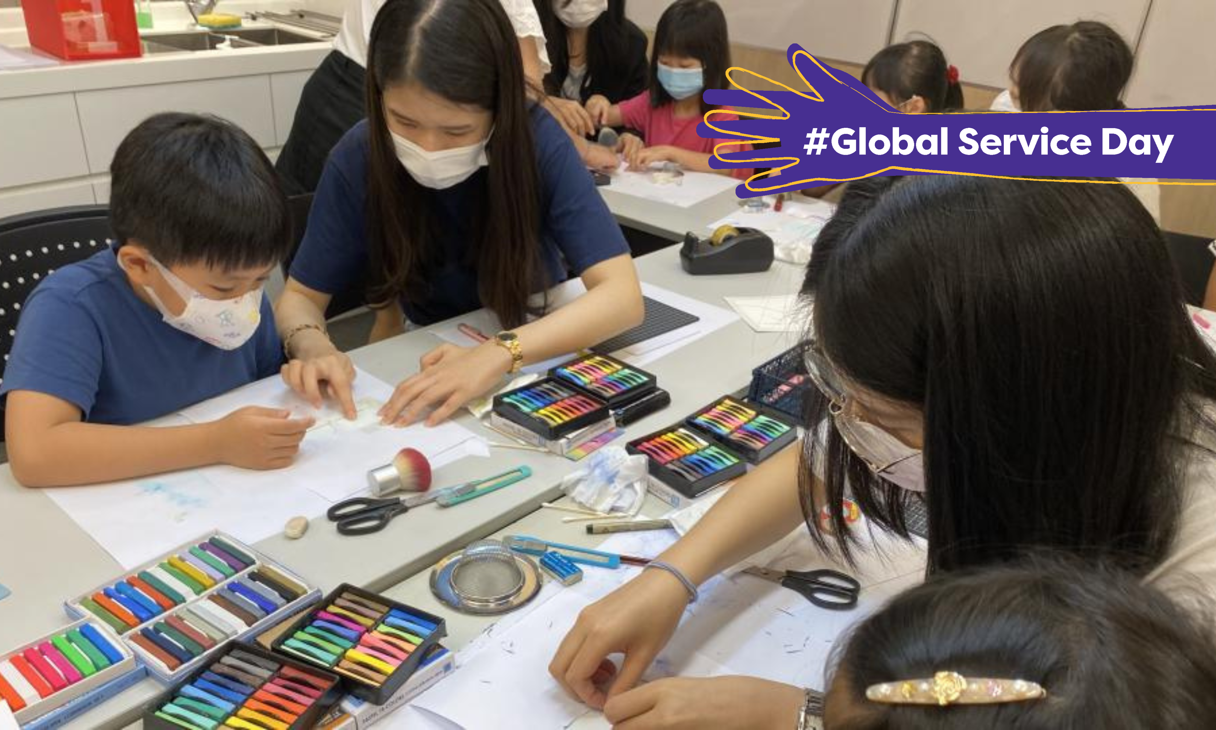 Volunteers helping children with their drawings.