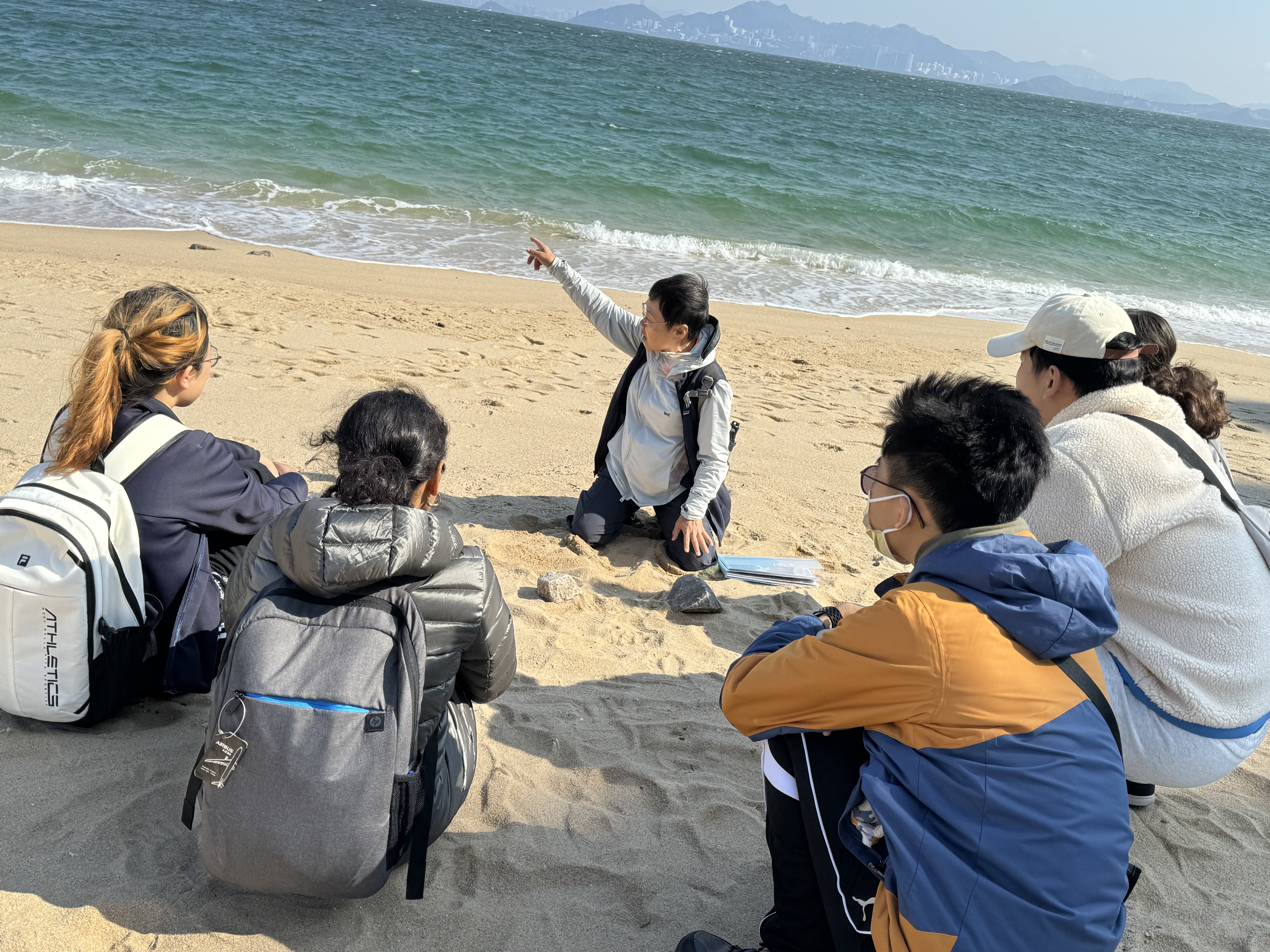 Volunteers sitting by the beach for briefing