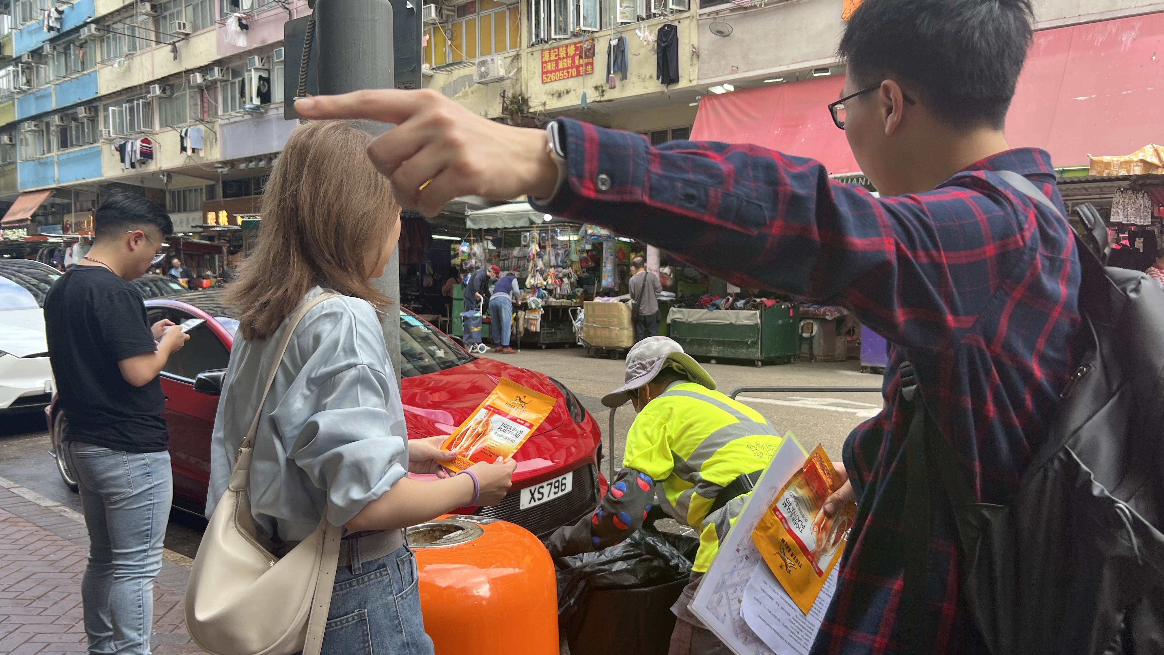 Students passing care package to street cleaners