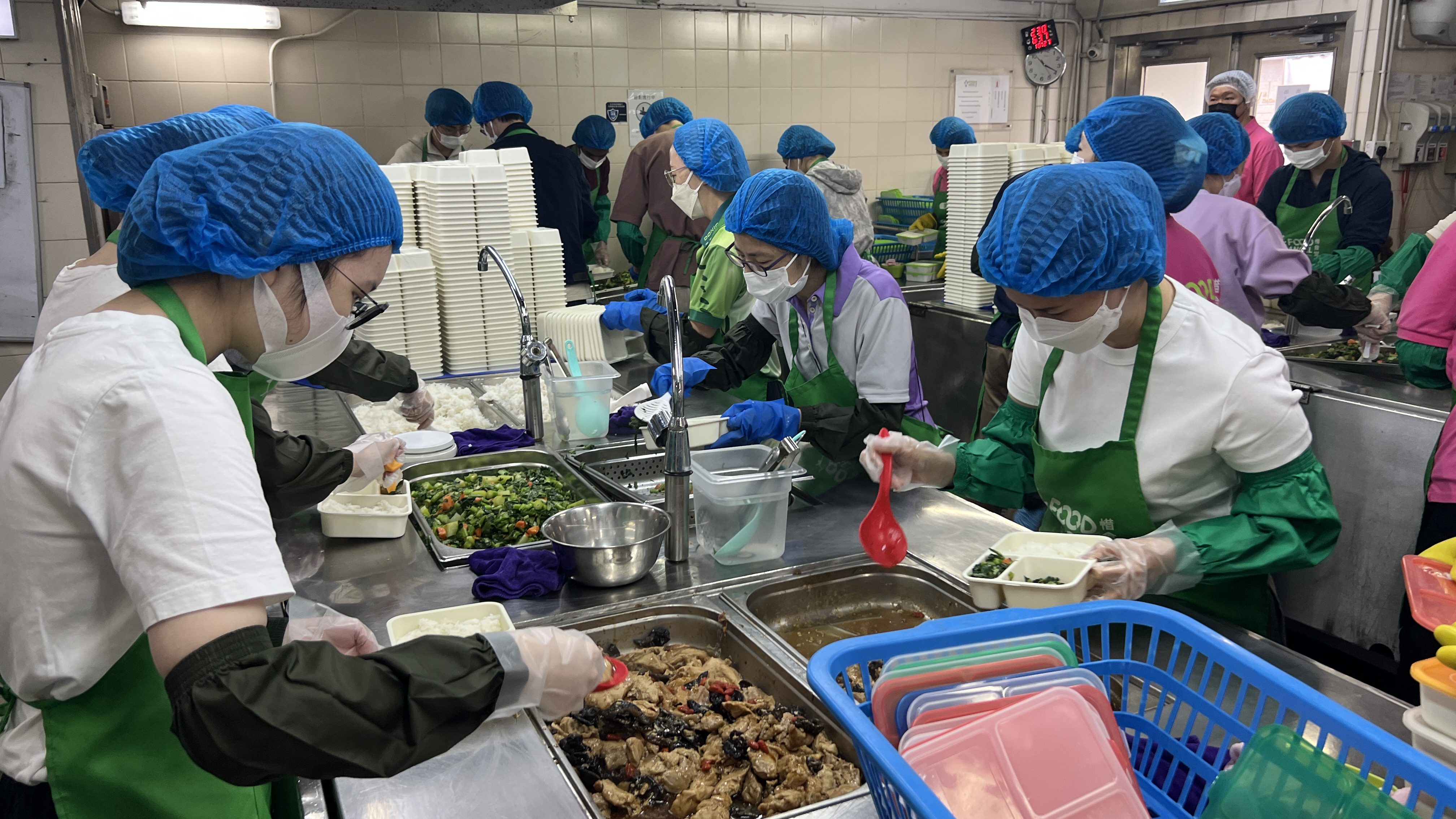 Volunteers preparing meal boxes using donated surplus food